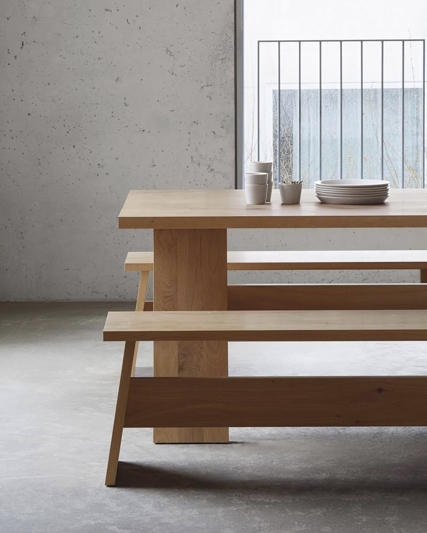 mesa de comedor de madera y banco con vajilla blanca