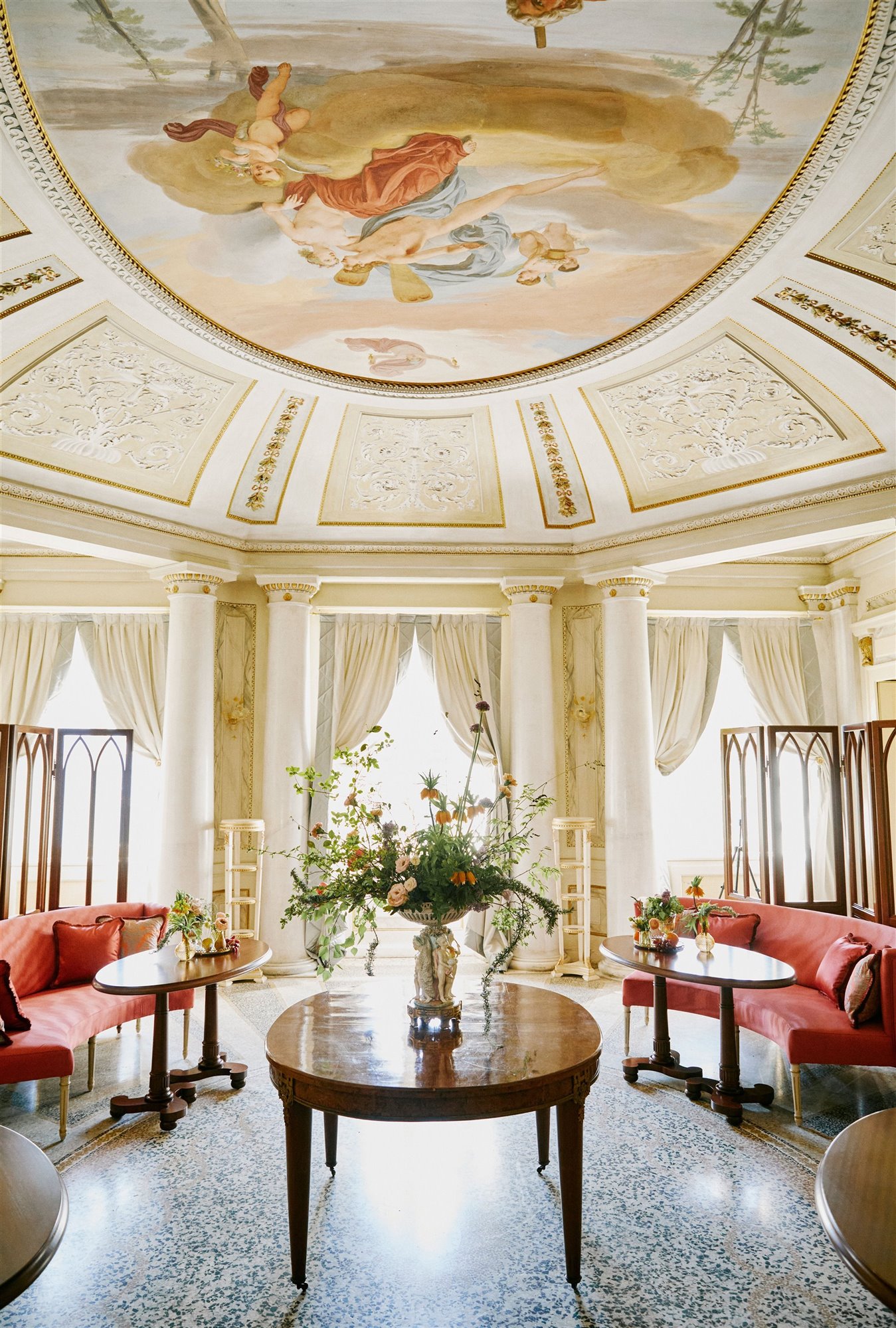 sala de estar con frescos en el techo y sofás rojos