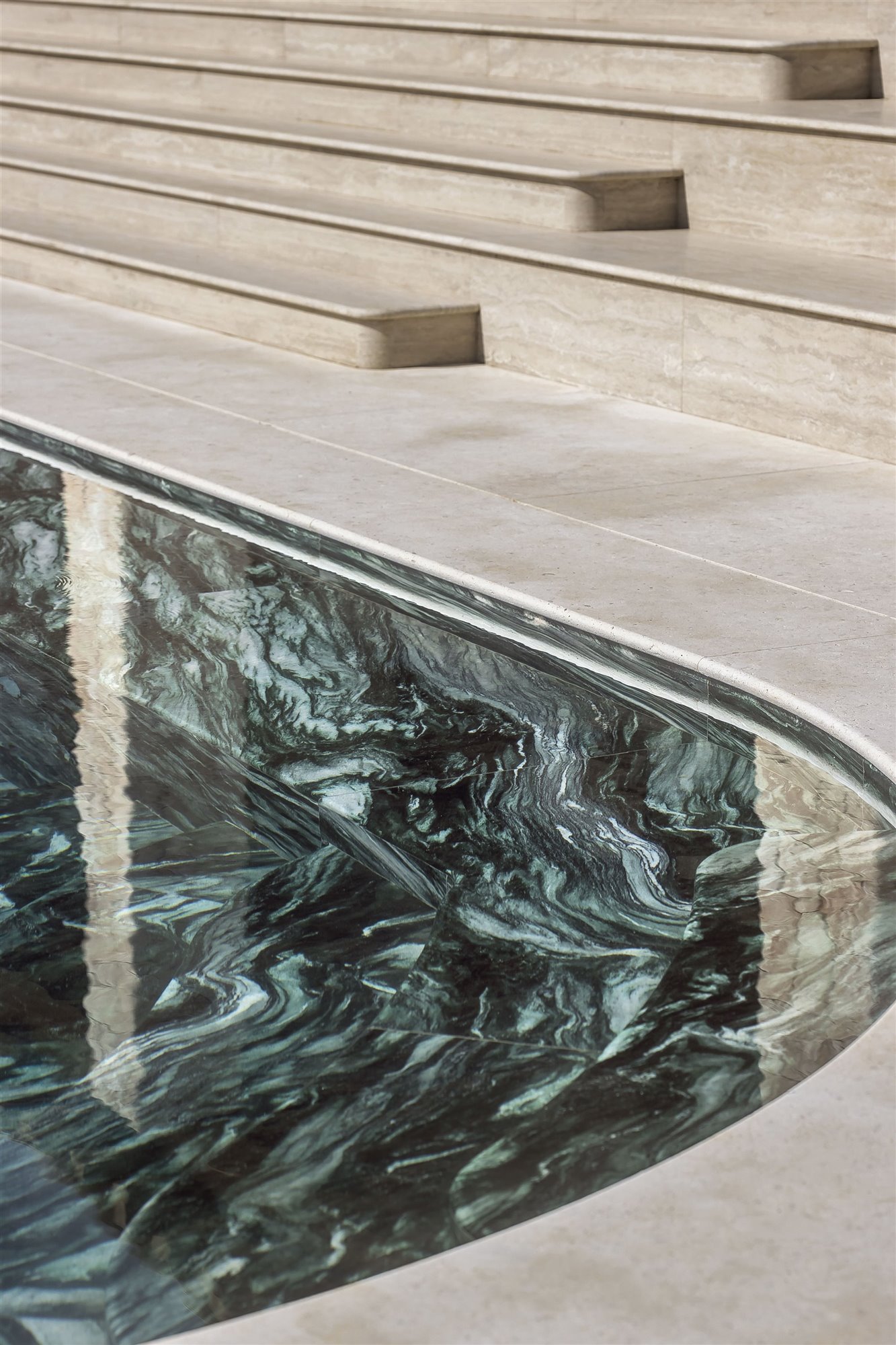 piscina de mármol verde y escaleras de mármol blanco