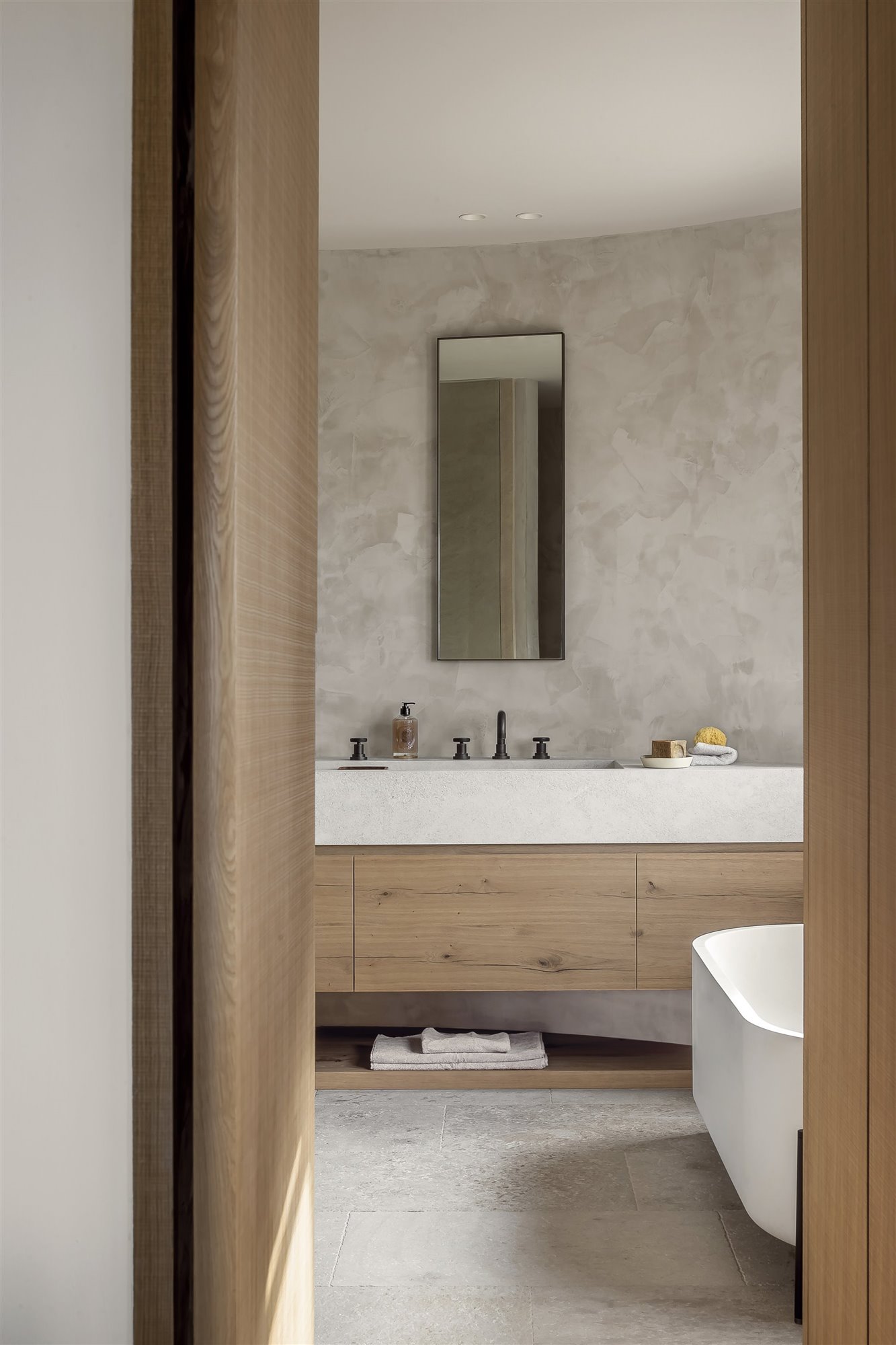baño rústico con pared de piedra y mueble de madera
