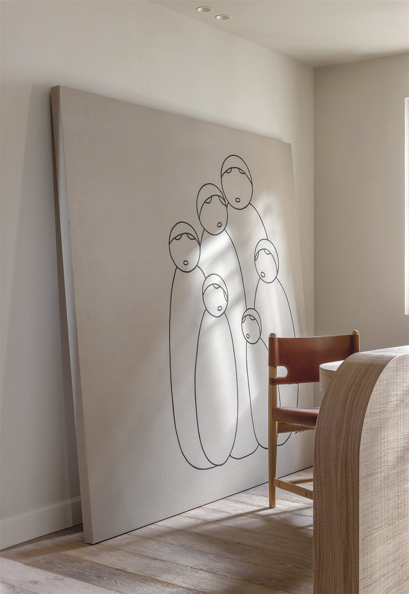 despacho con escritorio de madera y silla de piel, cuadro grande blanco