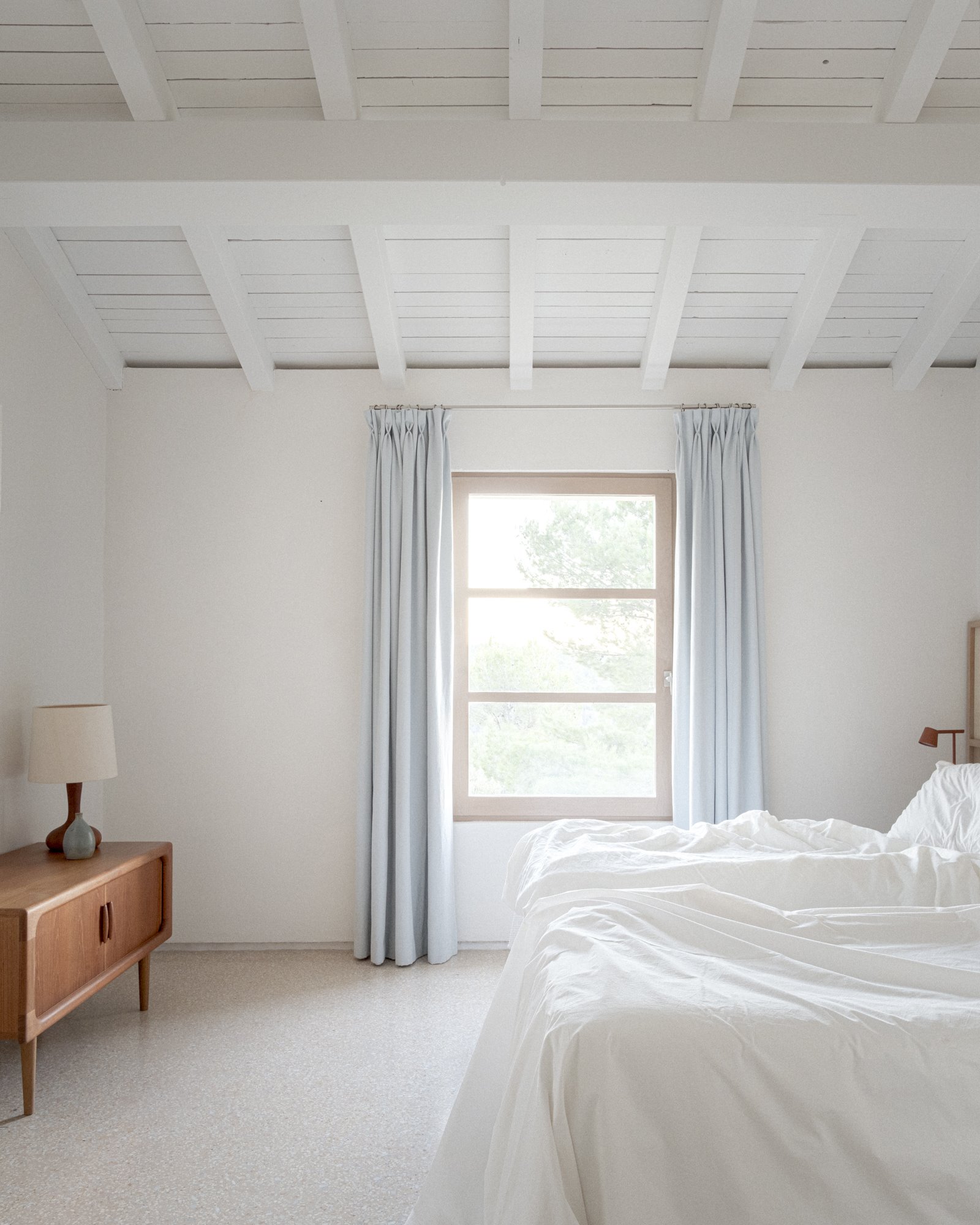 Dormitorio blanco con vigas vistas