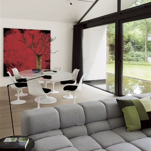 salón comedor con sofá gris, mesa redonda y sillas blancas, cuadro rojo