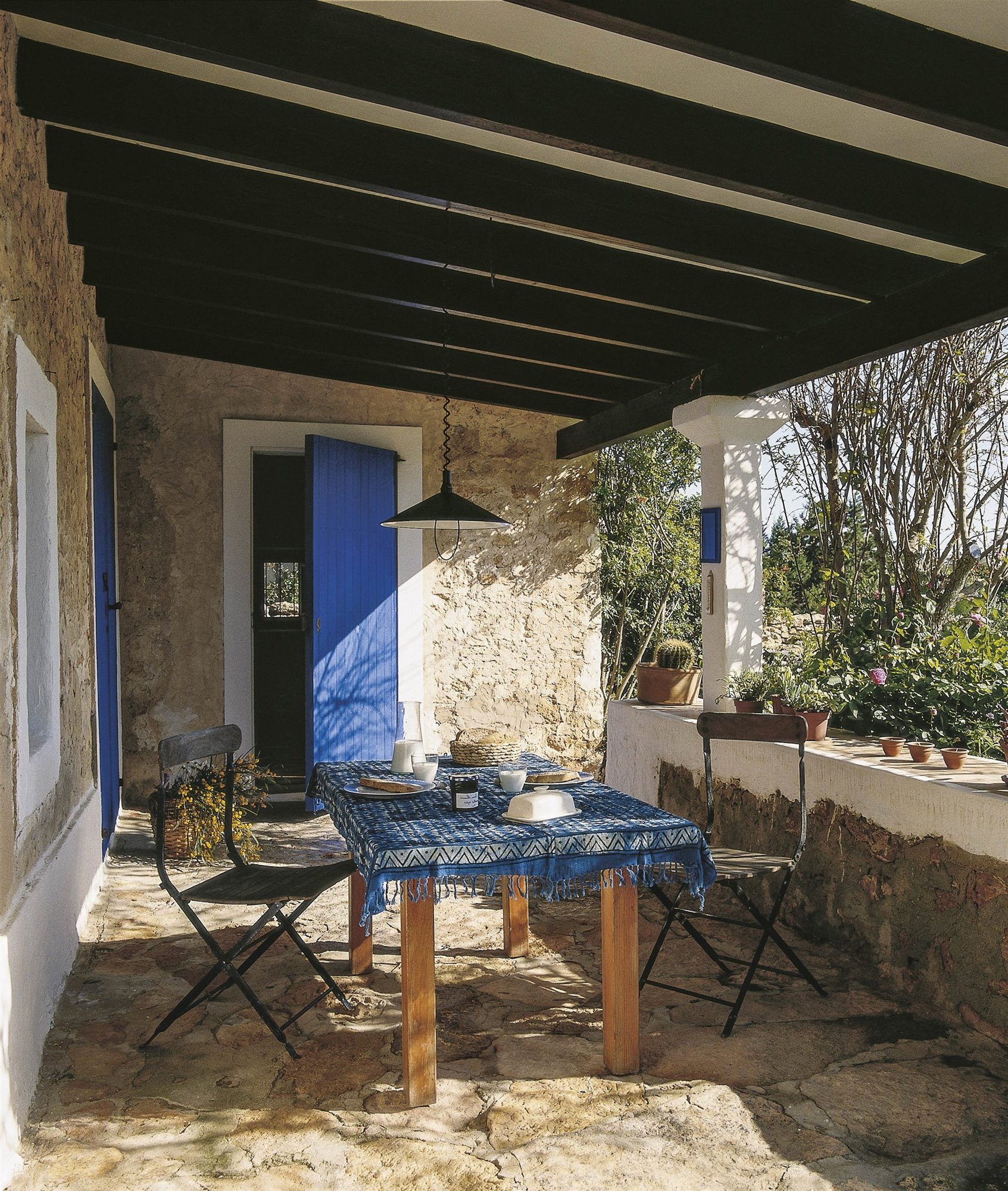 porche de piedra en casa de campo con mesa de comedor rústica