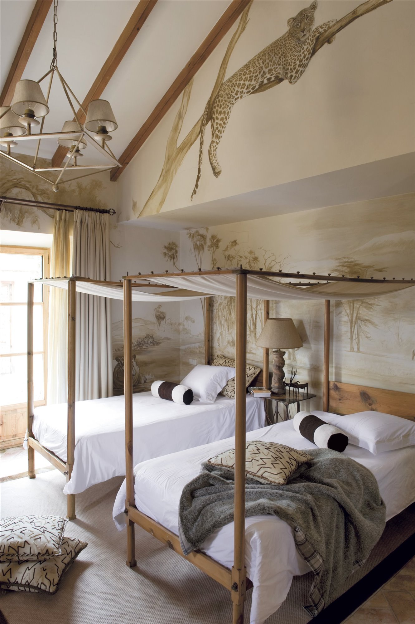 dormitorio estilo safari con fresco de animales, madera y cama con dosel