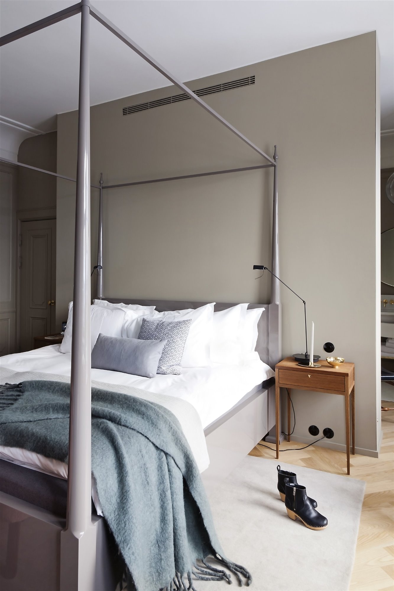 dormitorio sobrio gris cama con dosel y mesilla de madera
