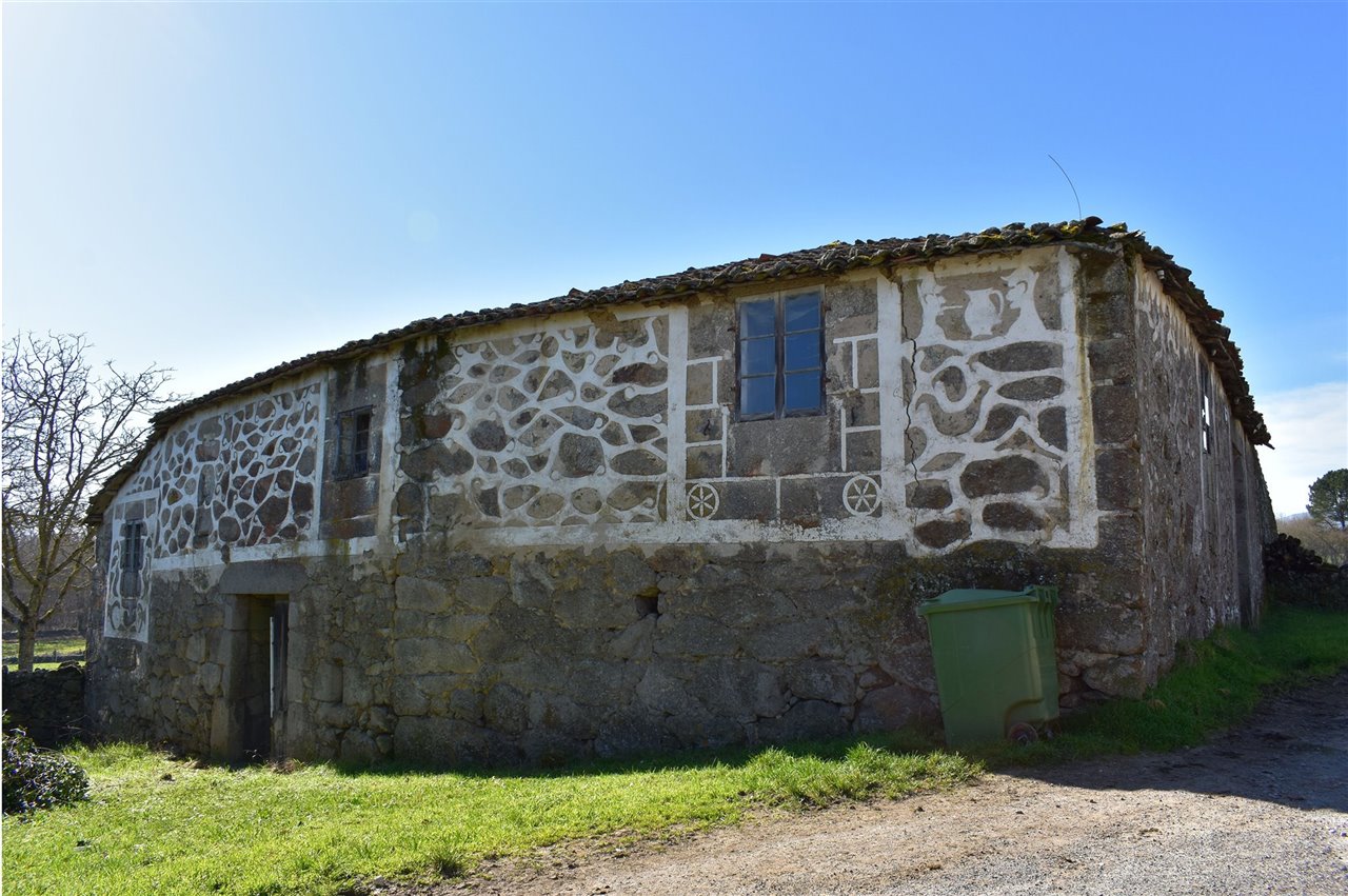 Fachada en Villarriño de Arriba, Taboada, Lugo. En ella se aprecian las hexapétalas, elementos de protección muy utilizados en el esgrafiado gallego.