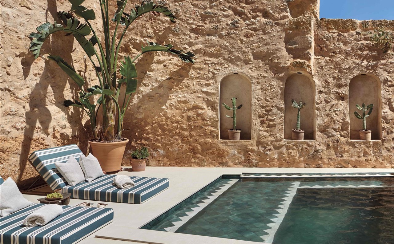El patio, de 65 m2, está orientado al sur y se ha transformado en un auténtico oasis de calma. Cuenta con una piscina climatizada, revestida con azulejos hechos a mano, y está equipada con chorros de jacuzzi y una cascada. Las cómodas camas de día son un diseño de Quadratmeta.