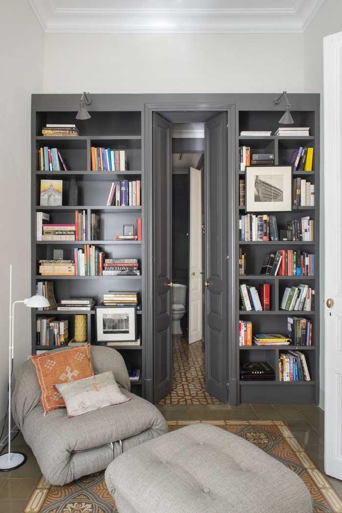 Despacho usado esporádicamente como habitación de invitados, con una biblioteca que esconde el acceso a un baño de cortesía. Por The Room & Co.