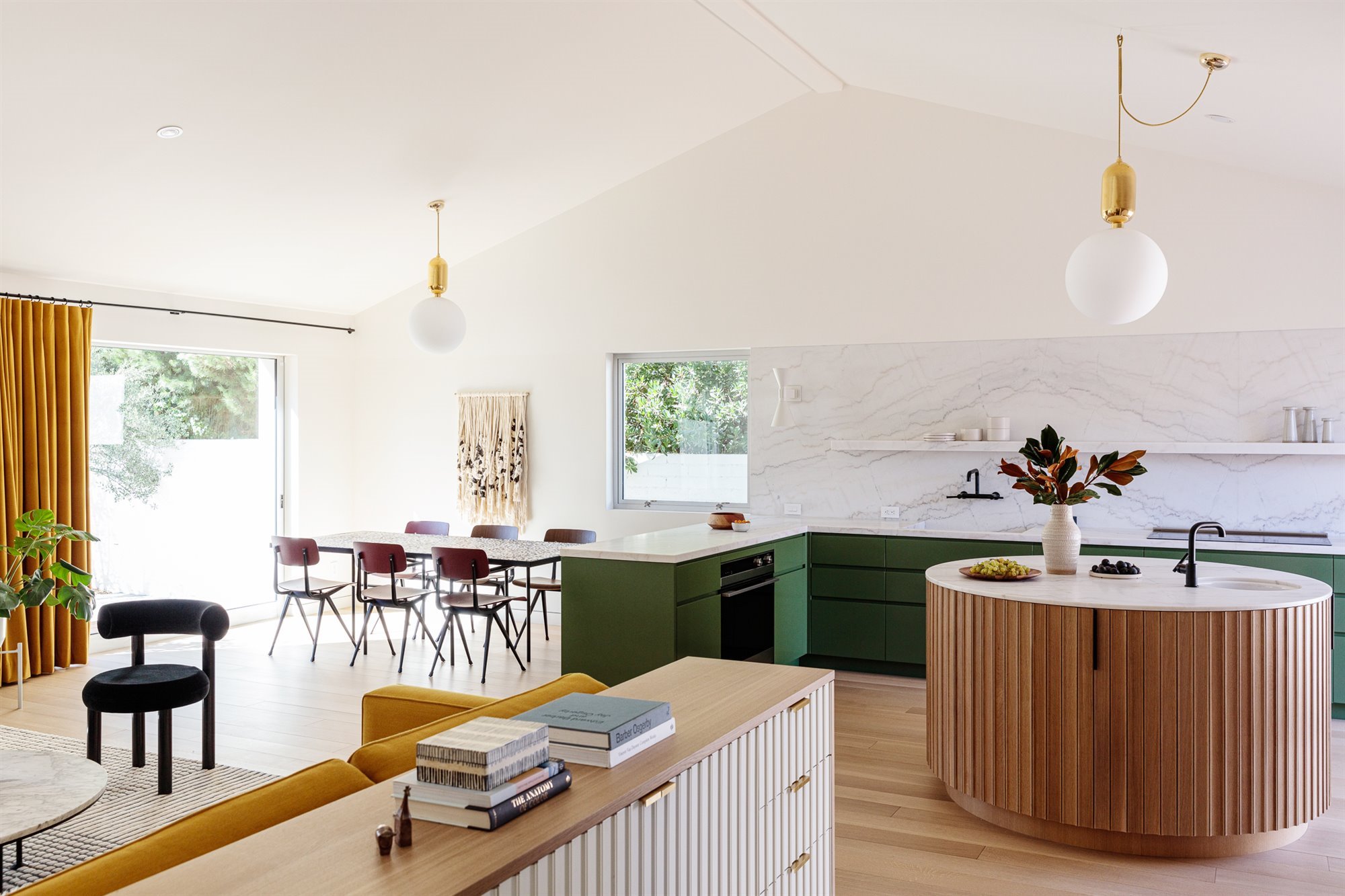 cocina con muebles de color verde e isla con forma ovalada