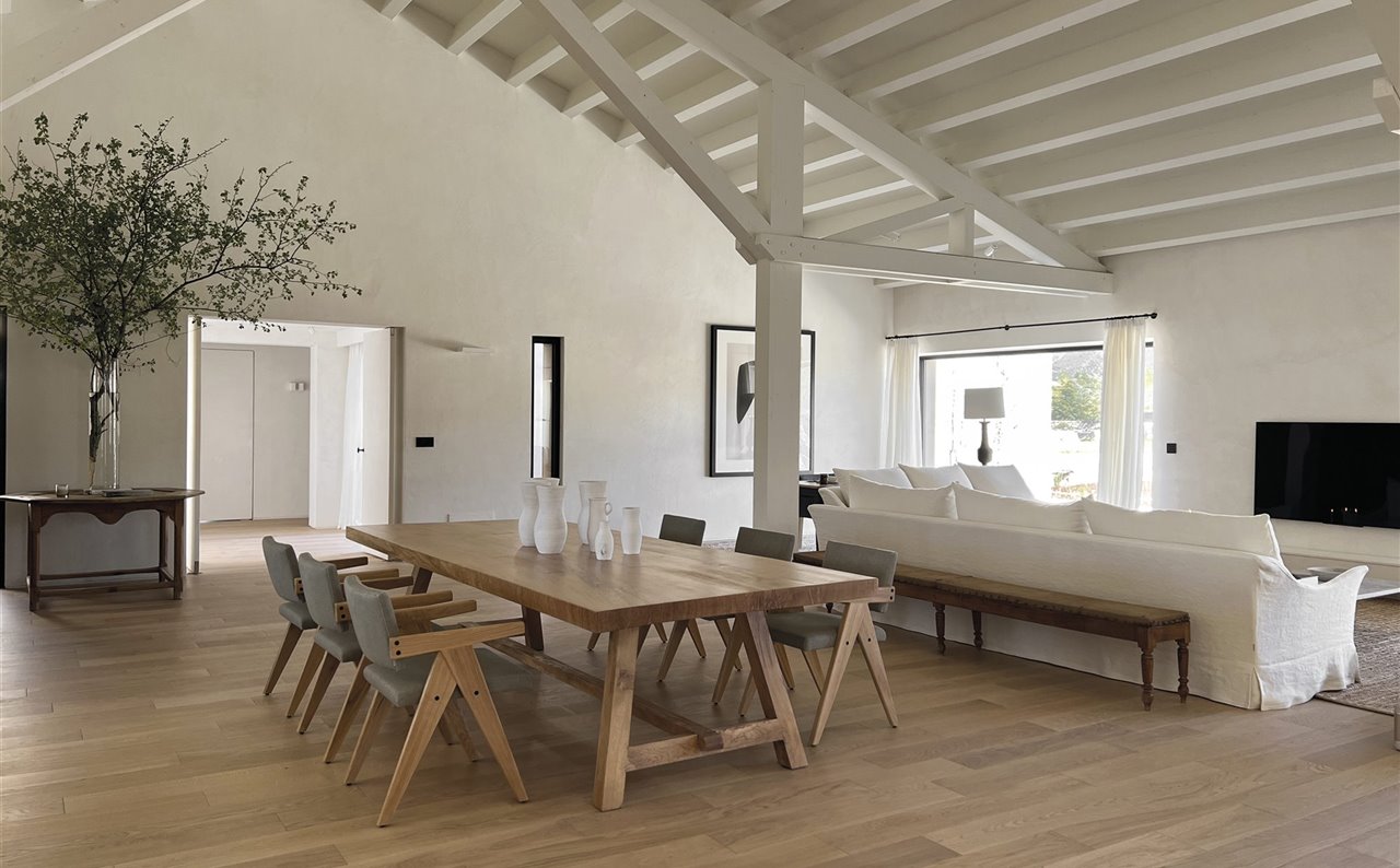 La vivienda se despliega en una sola planta sobre una superficie de 500 m2. La mesa de comedor es un diseño del estudio realizado a medida. Sillas Birdie Chair, de Blasco. El banco antiguo y los jarrones son de Berenis. A la izquierda, como aparador, una mesa de juego antigua.