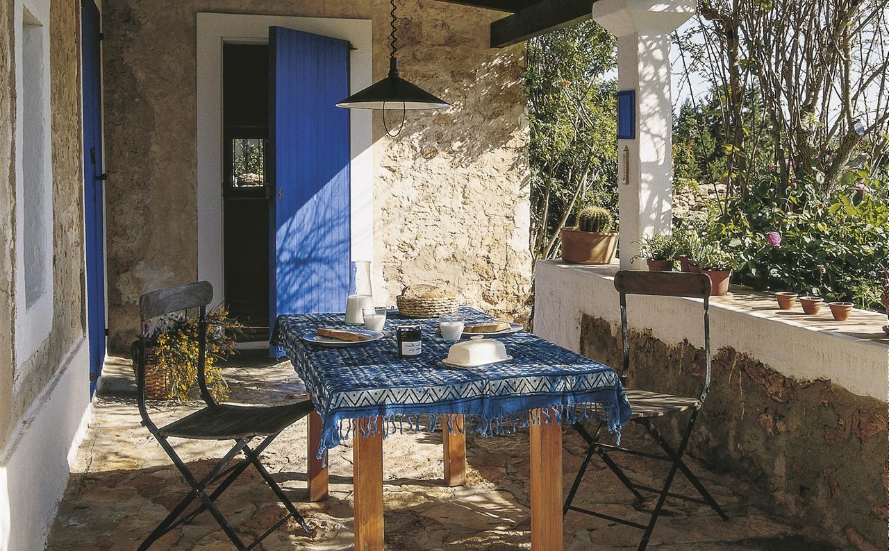 porche de piedra en casa de campo con mesa de comedor rústica