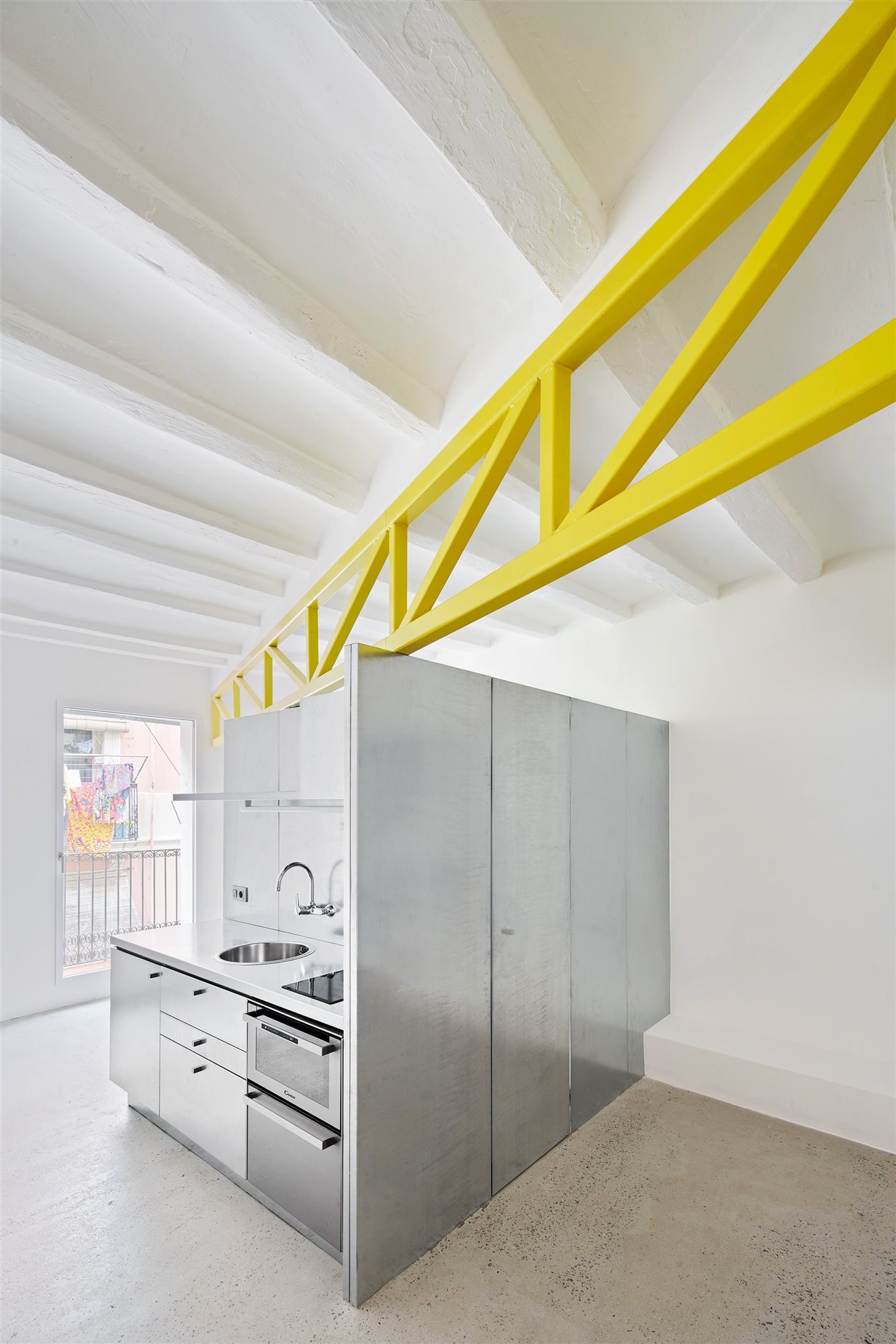 En el primer apartamento, la cercha amarilla no solo sirve de refuerzo estructural sino también de división visual. Foto: José Hevia