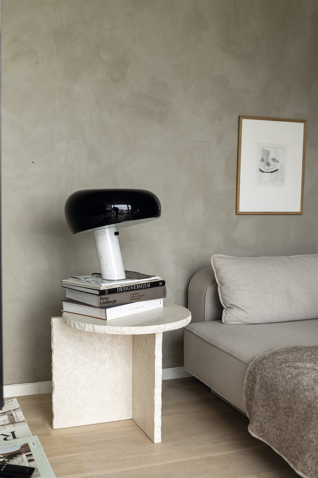 Dormitorio con la mesilla auxiliar Mineral Sculptural Table, de fermLIVING, y la lámpara Snoopy, de los Castiglioni para Flos.