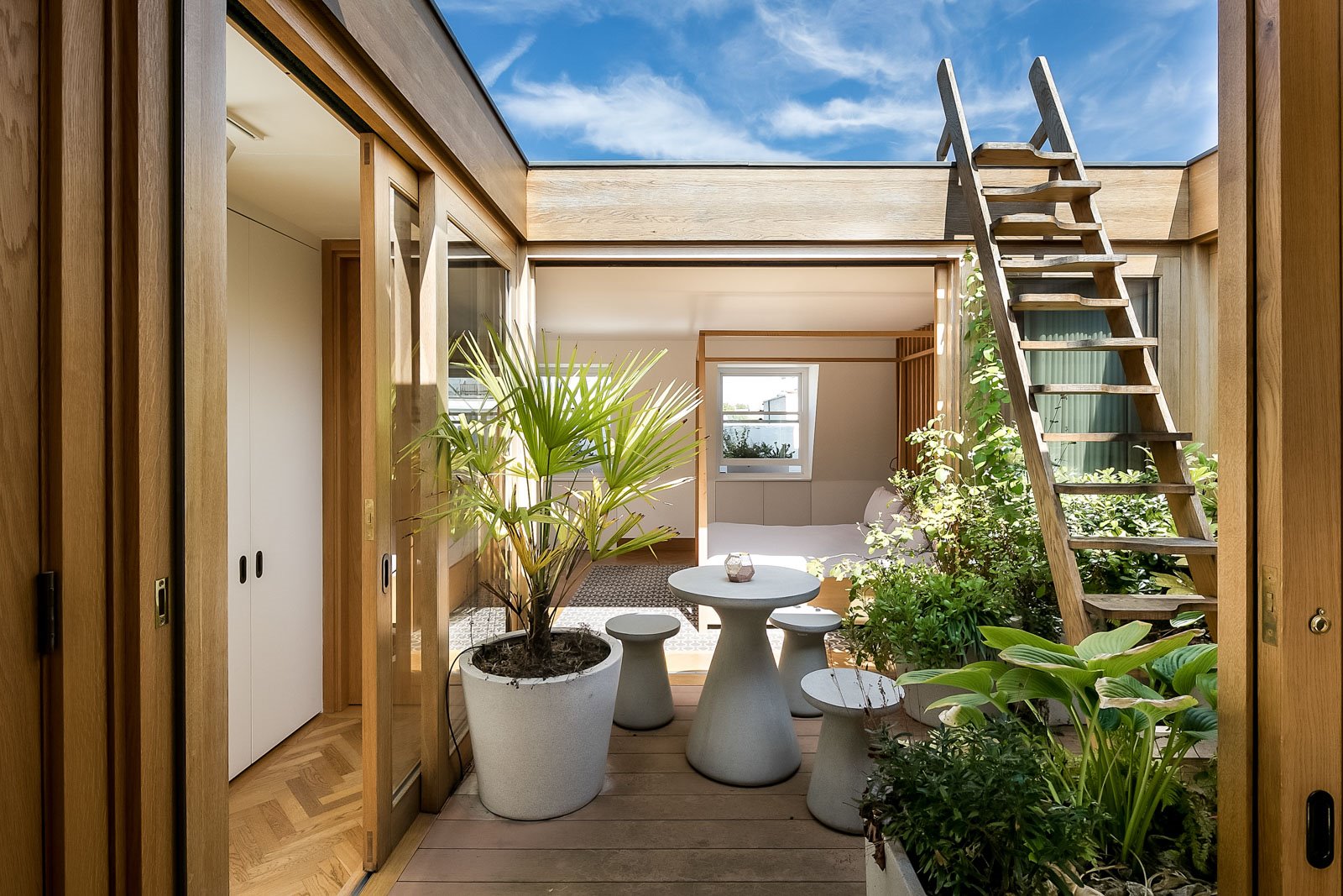 patio con jardín y escalera de madera que da a una terraza