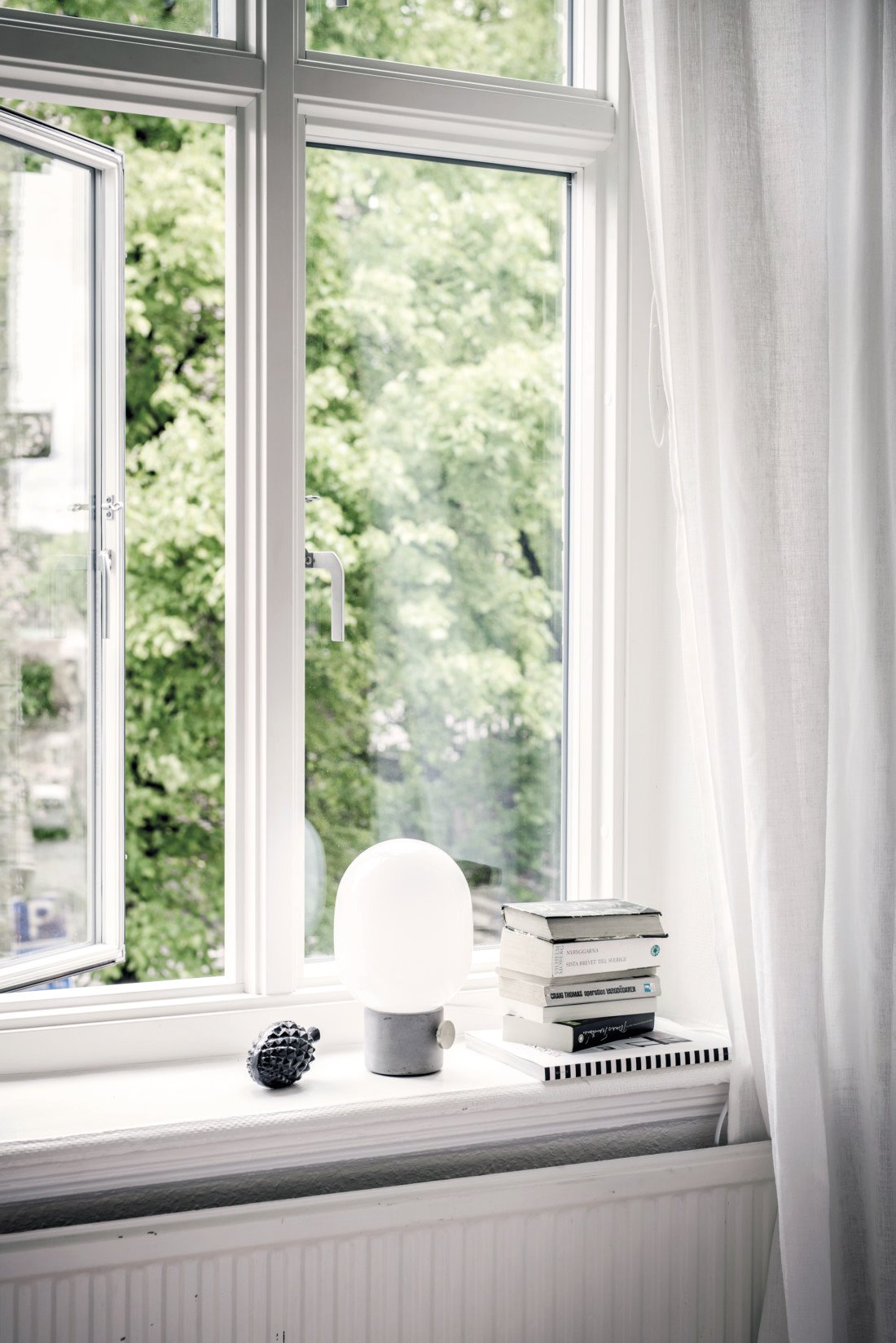 ventana con lámpara de mesa blanca y libros