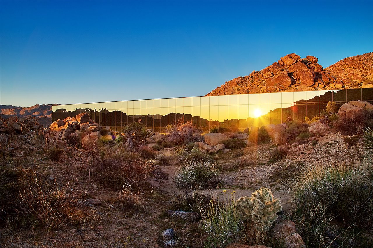 La casa tiene forma de caja y sus paredes reflejan el paisaje.