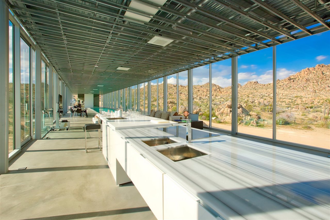 Sobre un suelo de cemento y estética minimalista, la cocina está equipada con electrodomésticos de alta gama.