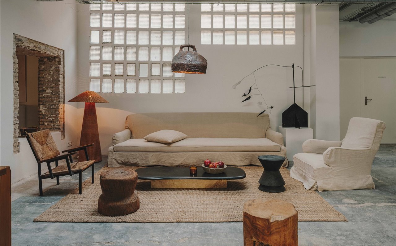 Un espacio de estar con estética muy doméstica donde el equipo puede relajarse, con una lámpara de pie Dou, de ratán, y un móvil inspirado en Alexander Calder.