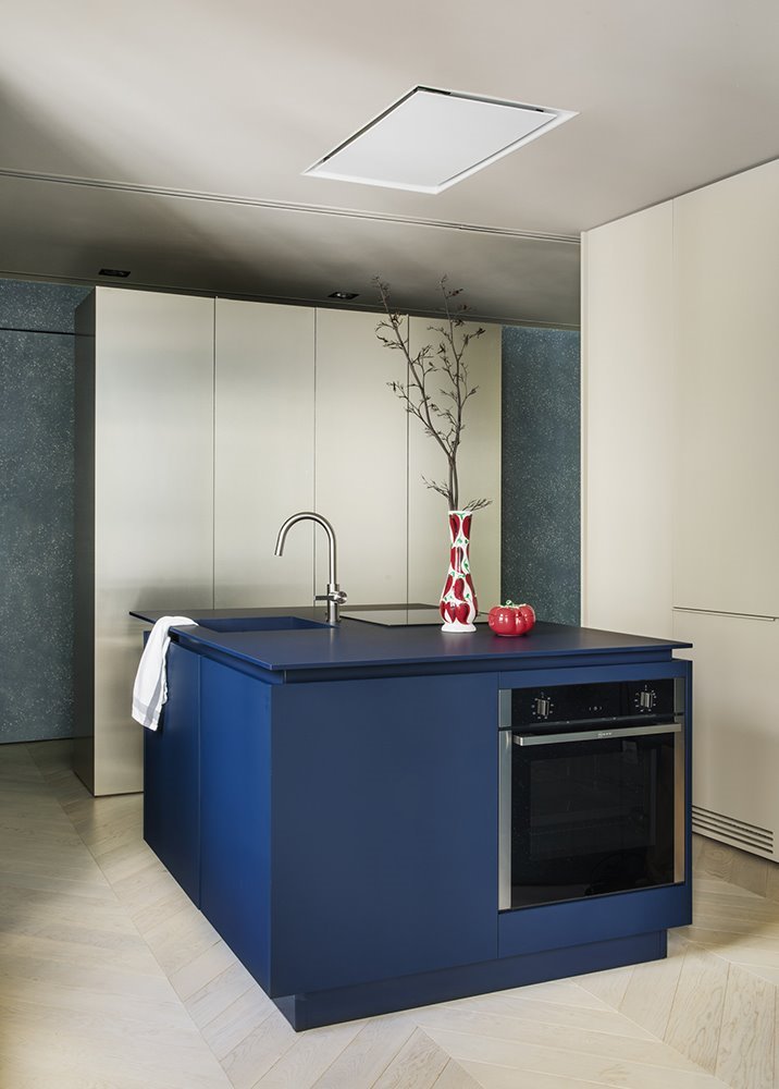 Febrero Studio diseñaron una sorprendente isla de cocina en un vibrante azul marino que esconde de la vista todas las funciones que se le piden a una isla de cocina.
