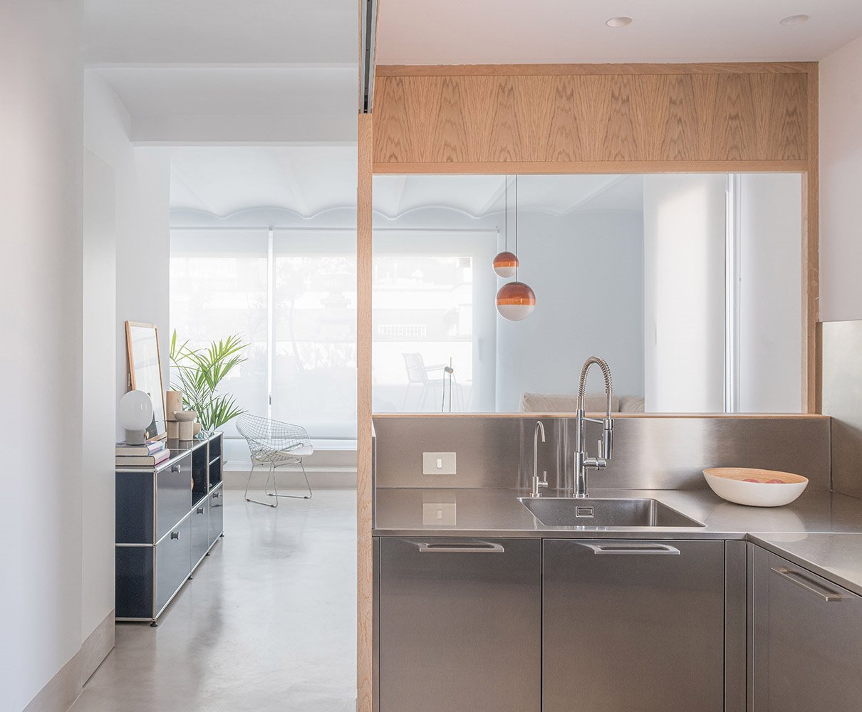 Metálicos y haciendo de zona de paso, así lo resolvió Bonba Studio en este apartamento de Barcelona.
