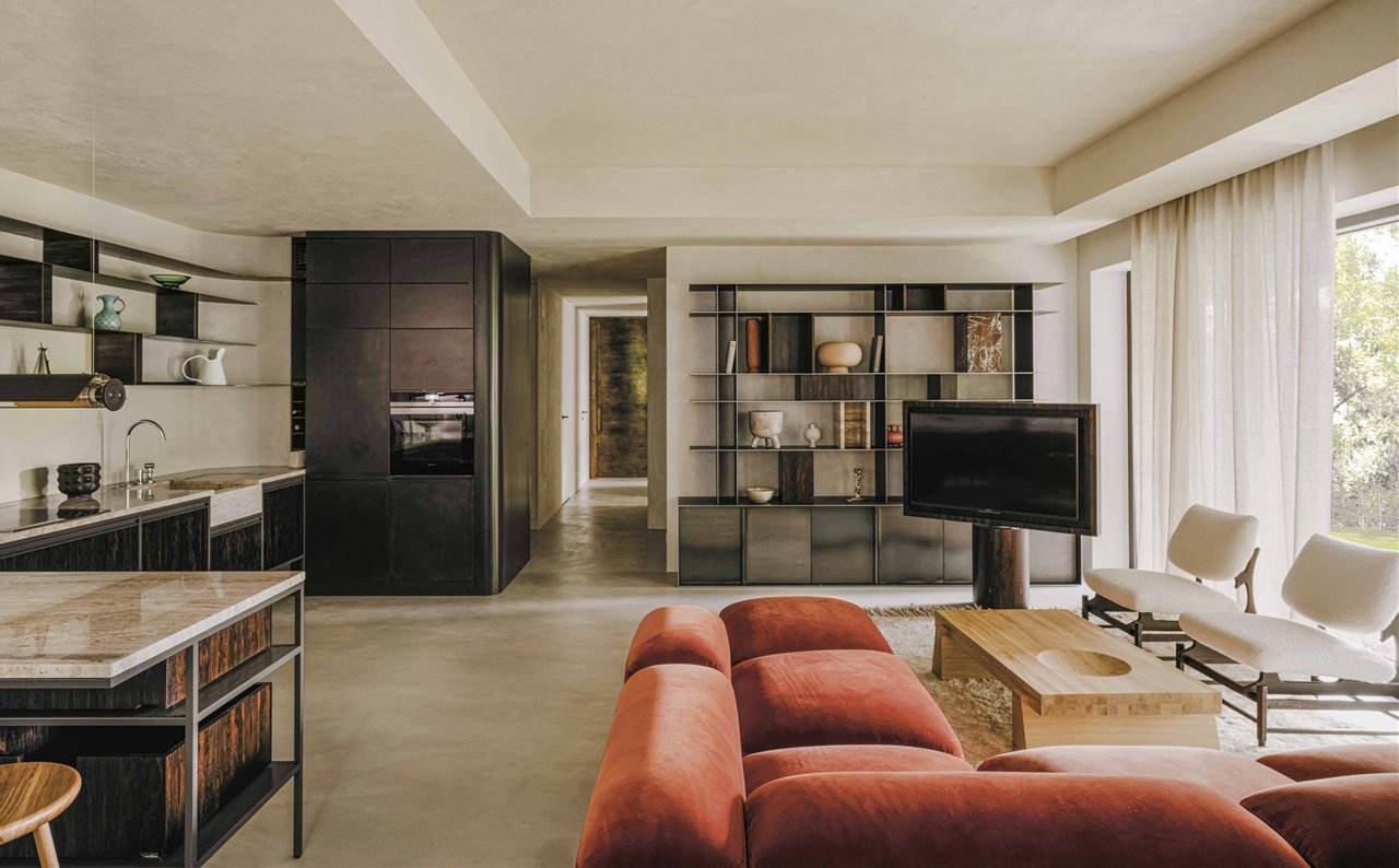 El salón y la cocina ocupan un mismo espacio. Esta fue proyectada con estilo muy decorativo para darle un uso ocasional. El retranqueo en el techo sirve para ocultar el sistema de ventilación y la iluminación perimetral. El suelo es de cemento pulido y las cortinas de lino, de Dedar.