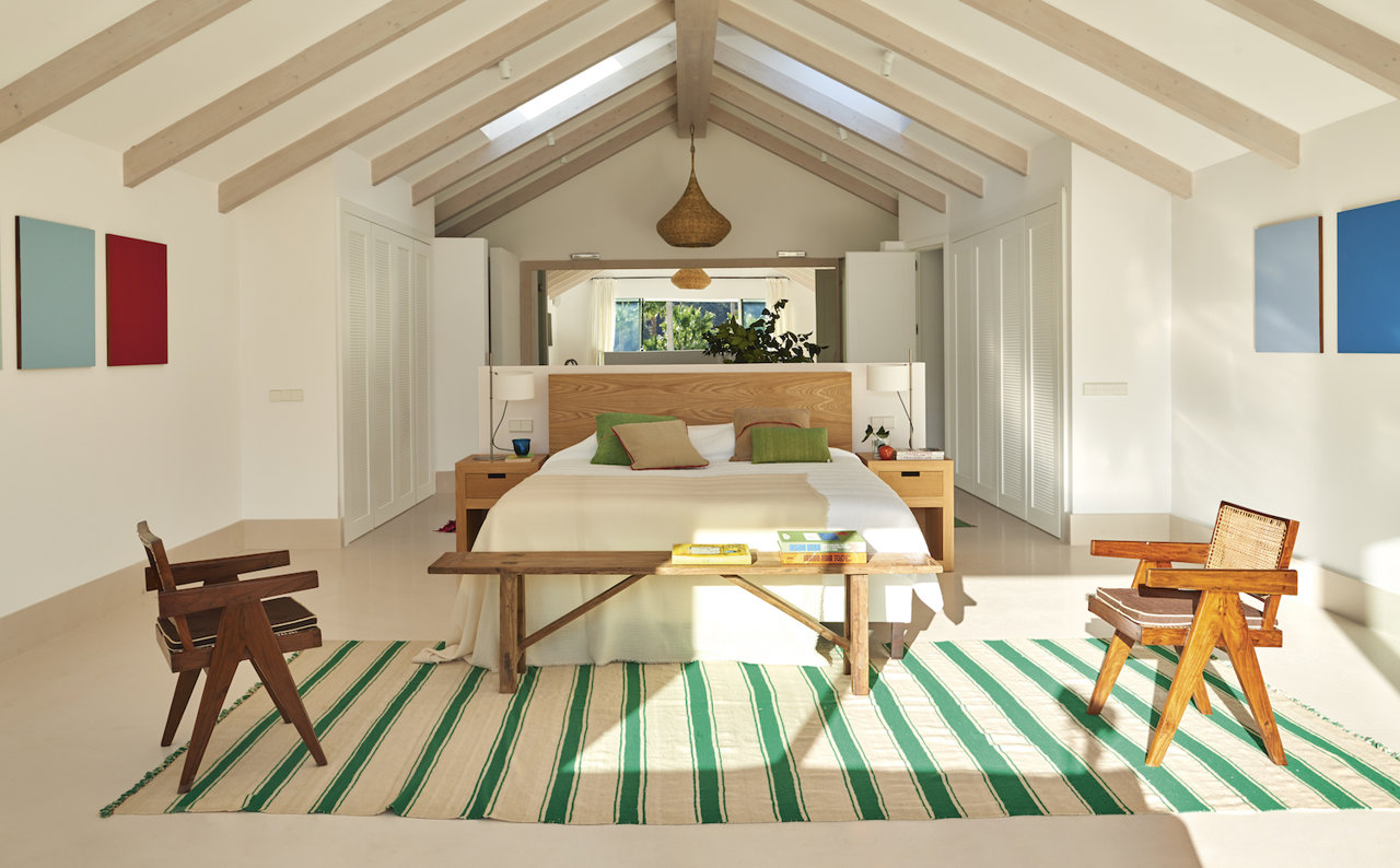 Dormitorio moderno con vigas en el techo y alfombra de rayas verdes