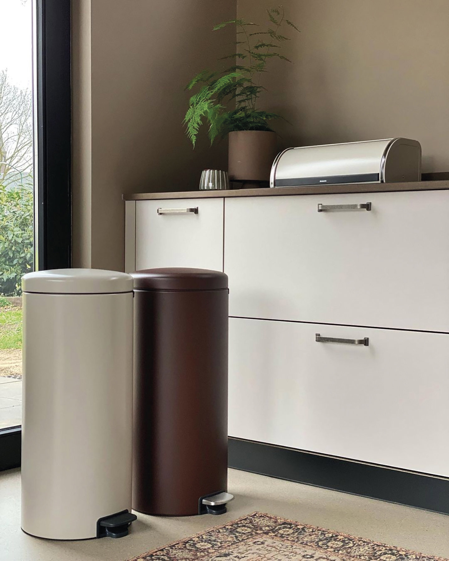 Cubos meta´licos con pedal NewIcon y, sobre la encimera, panera Classic, todos de Brabantia.