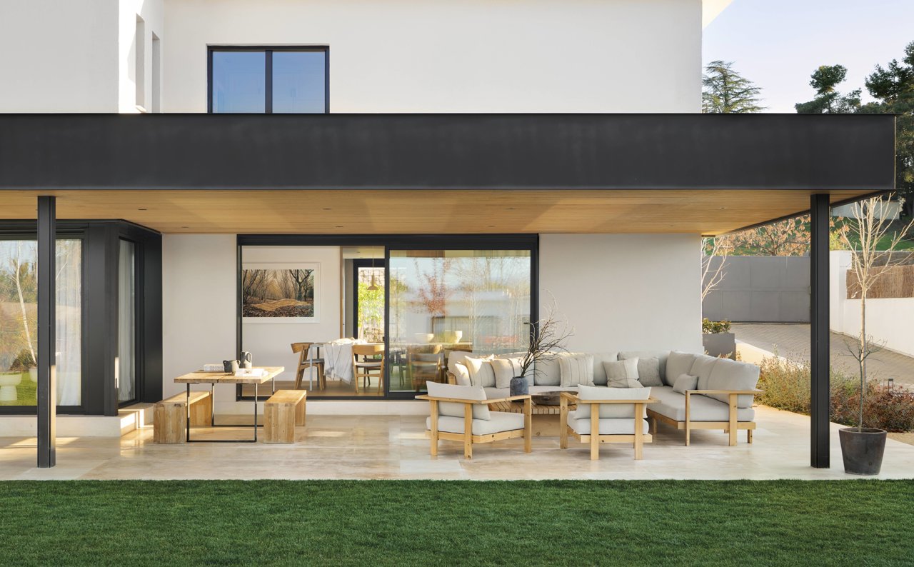 Con estructura de hierro y lamas de madera que filtran la luz. El sofá, los sillones y la mesa de centro son también obra del estudio. Estilismo: Susana Ocaña