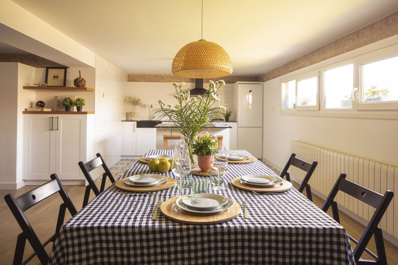 Comedor y cocina de un txoko en el País Vasco diseñado por Raquel González.