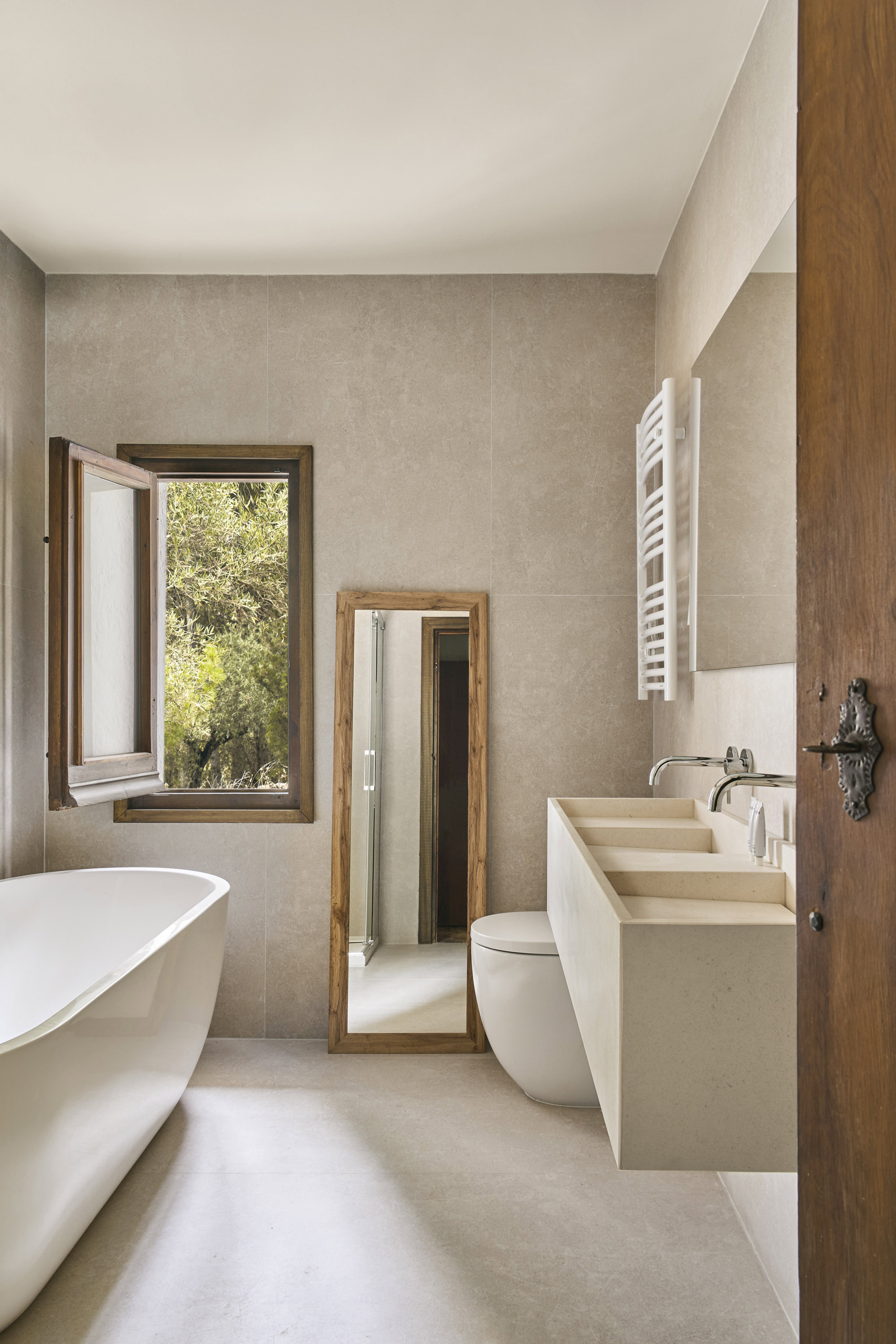  Baño con lavabo a medida de piedra caliza blanca paloma, diseño de Bueno; grifería, de Rovira, y bañera, de Hudson Reed.