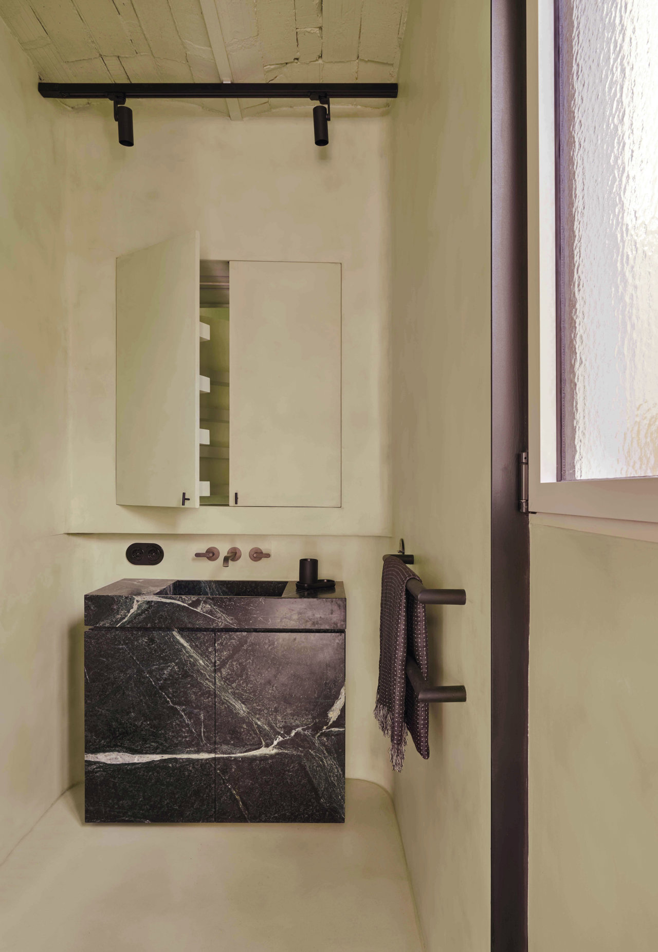 En el baño, con lavamanos de mármol Guatemala, grifos de la serie Icona Deco, de Vincent Van Duysen para Fantini