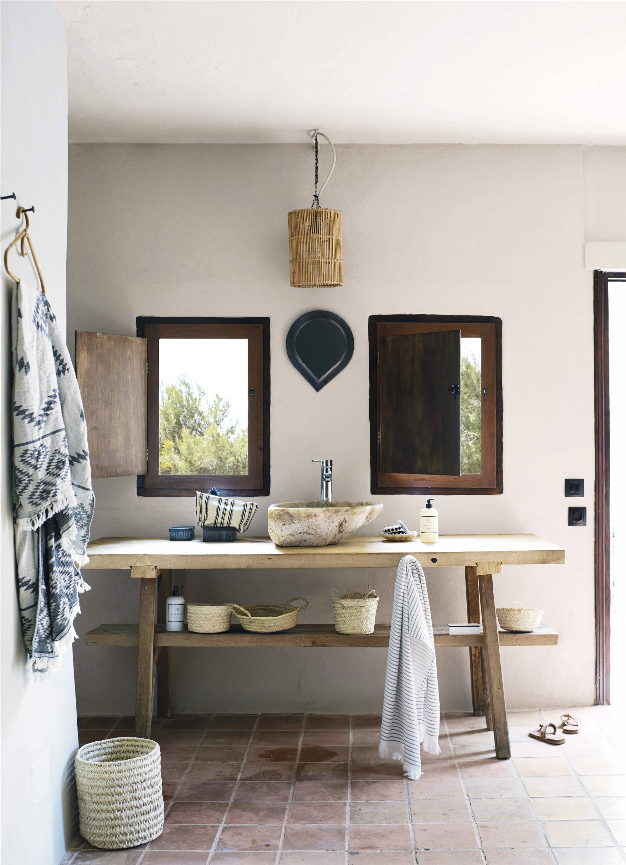 baño rústico con pileta de piedra y mueble de madera.