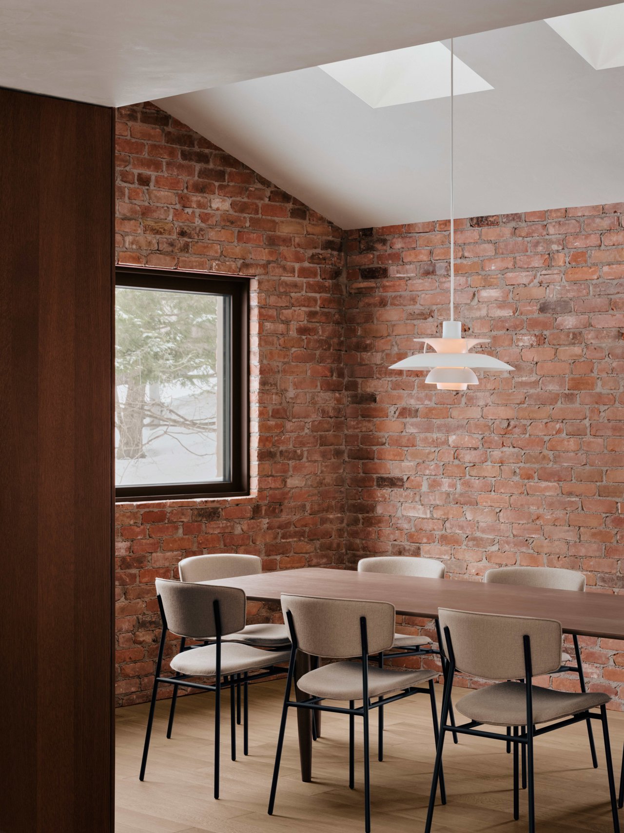 Dining room with brick cladding and natural oak floors