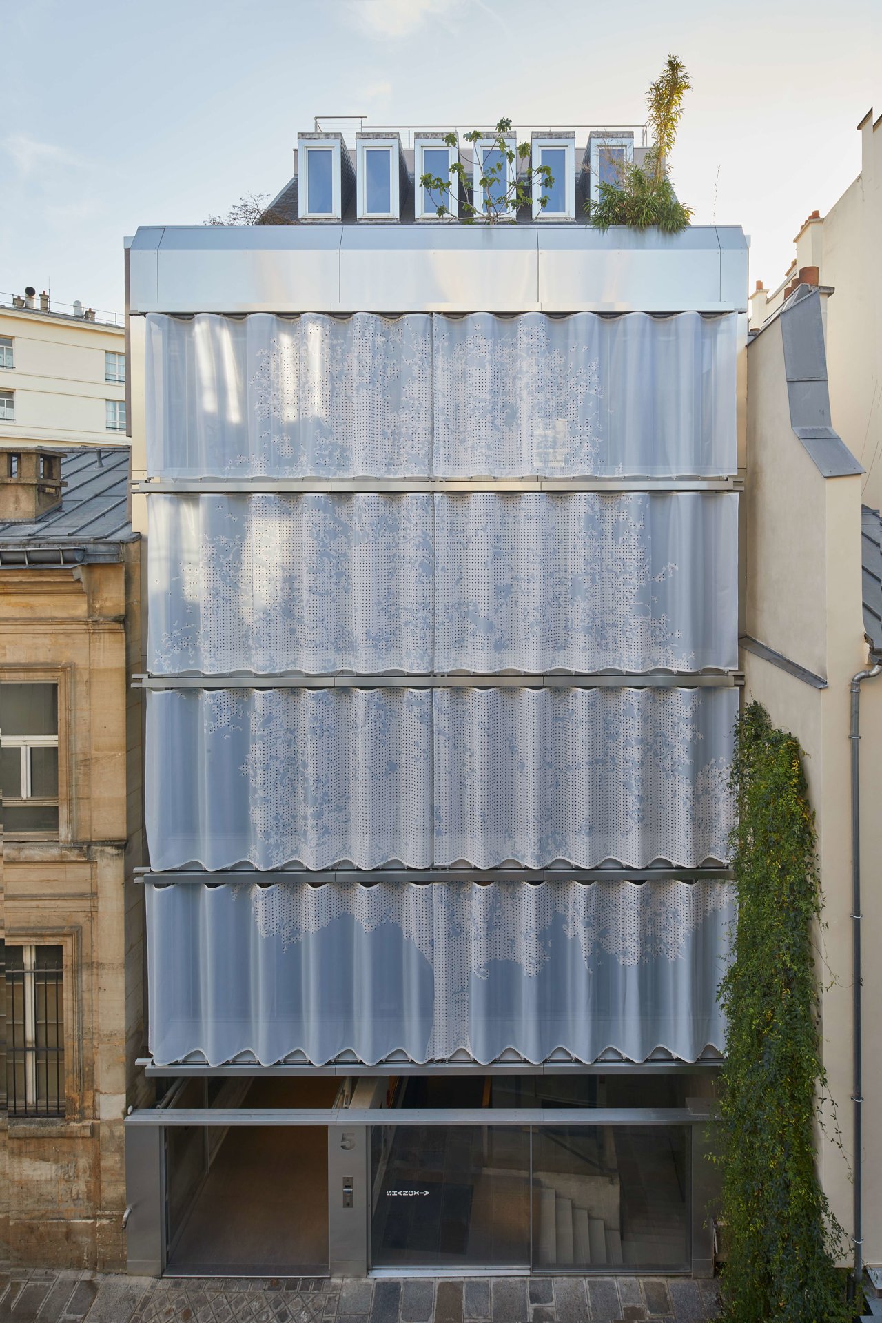 La silueta de un pruno se intuye en la cortina de 10 m que cubre la fachada de un edificio de los años setenta en la parisina Rue du Vertbois, de Inside Outside con Moussafir Architectes.