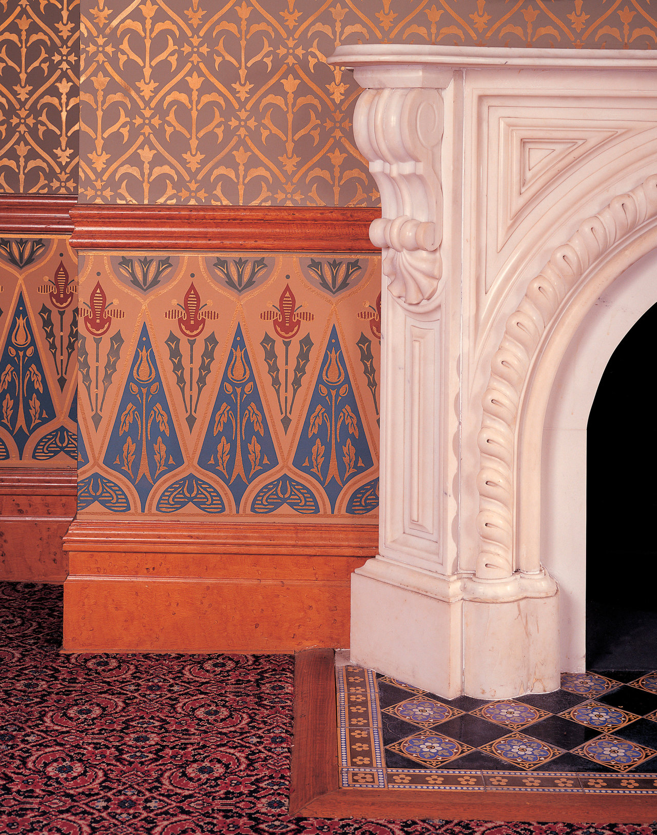 En el dormitorio de Jed, chimenea de mármol blanco de mediados del XIX se complementa con el intrincado papel pintado. Los azulejos del suelo, la carpintería y la moqueta completan el diseño.