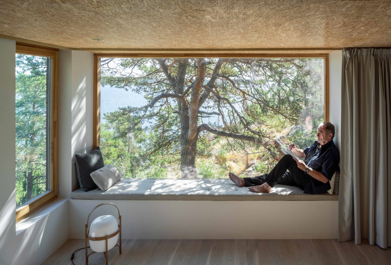 En un banco hecho de obra junto al enorme ventanal, el arquitecto y propietario de la casa, Rickard Rotstein