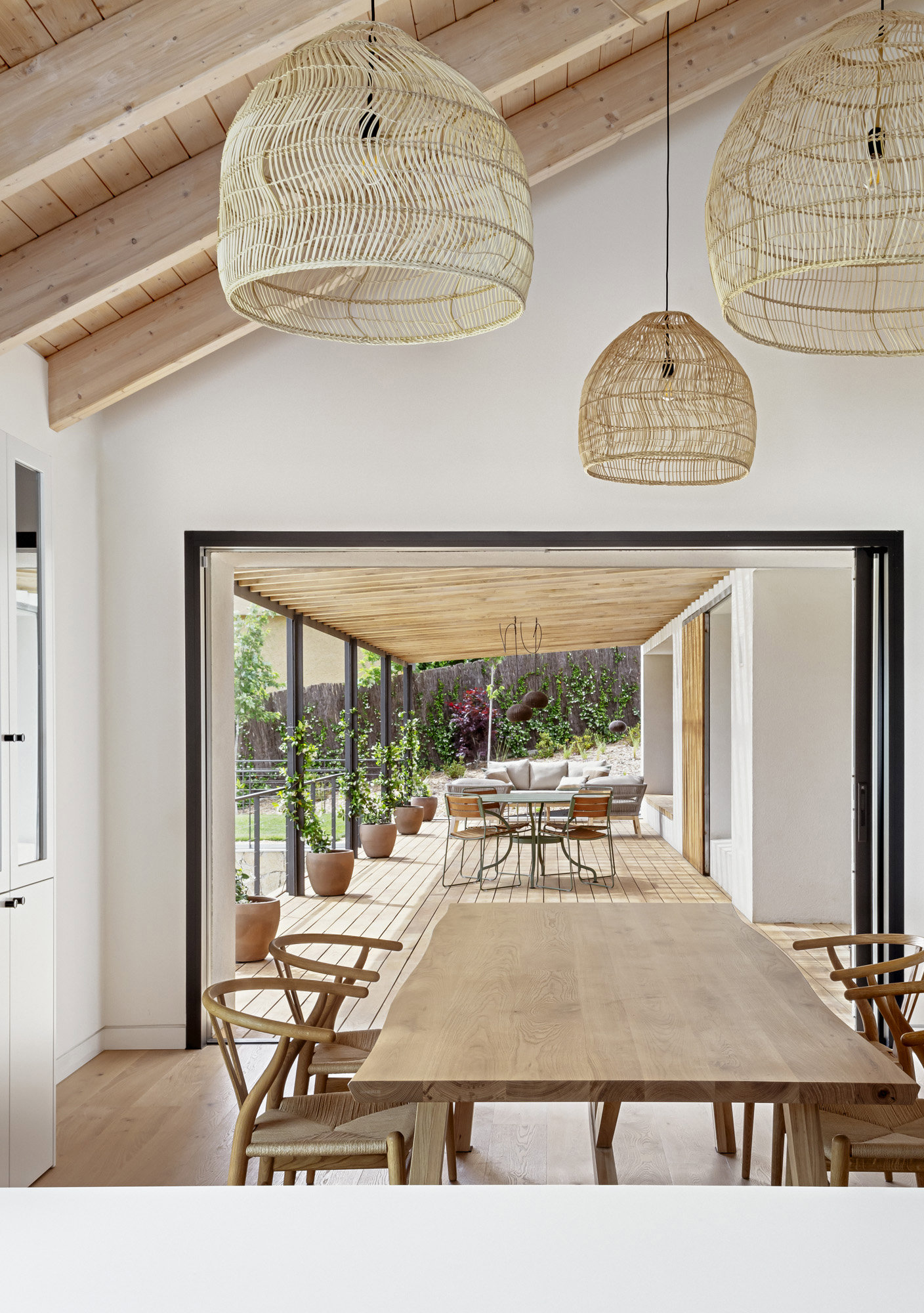 En la cocina, la contundencia de la mesa comedor de Heerenhuis y las sillas CH24 de Carl Hansen contrastan con la ligereza de los muebles y las lámparas de ratán.