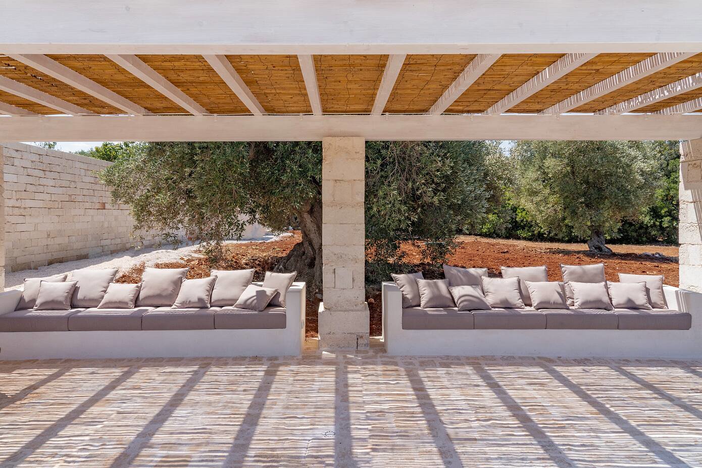 Casa en Italia con fachada de color blanco porche con sofas de obra