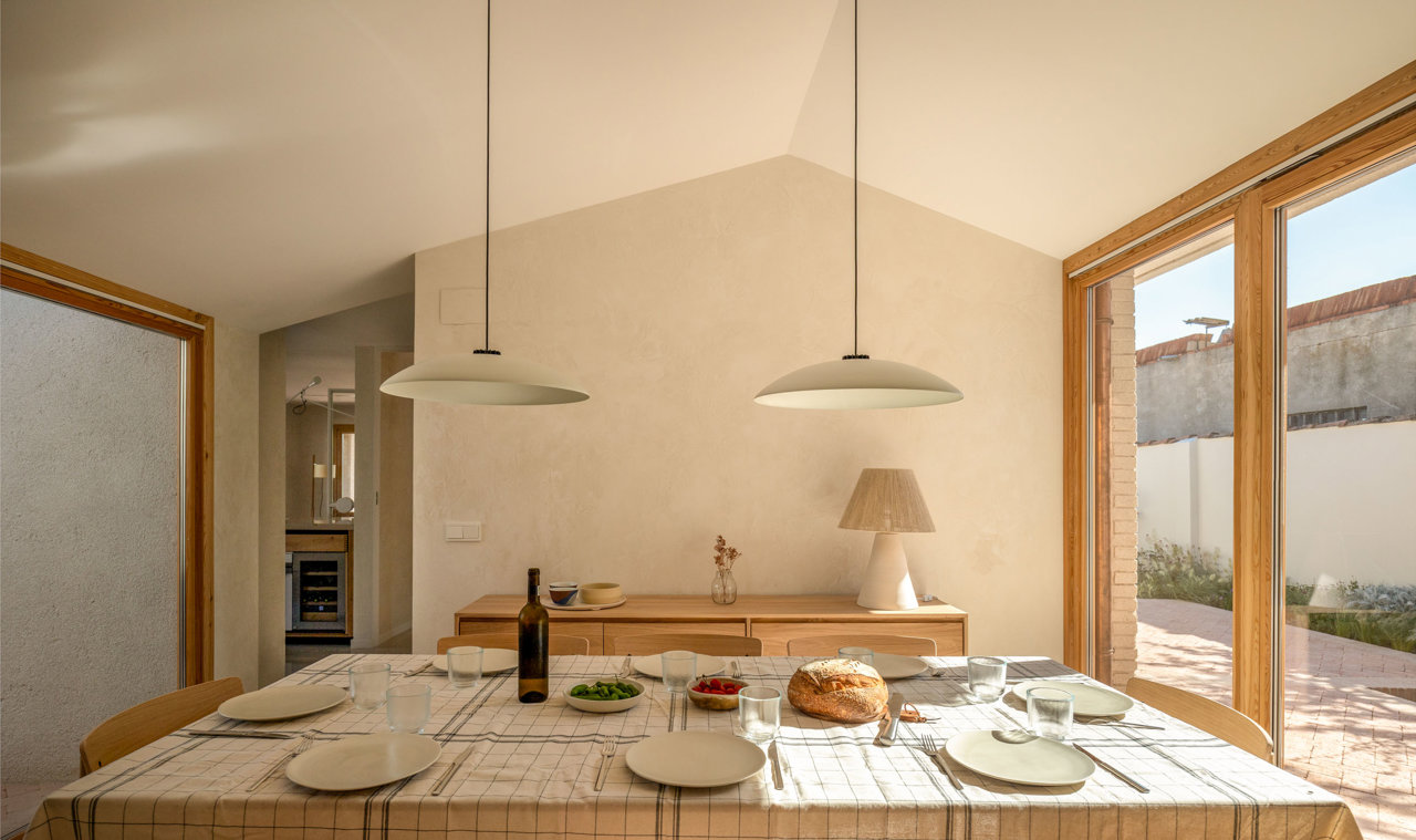 La mesa de comedor y el mueble contenedor son de Ethnicraft, las sillas Cross son de Takt, la lámpara de sobremesa es de Les Eines y las de techo modelo HeadHat Plate las produce Santa & Cole. 
