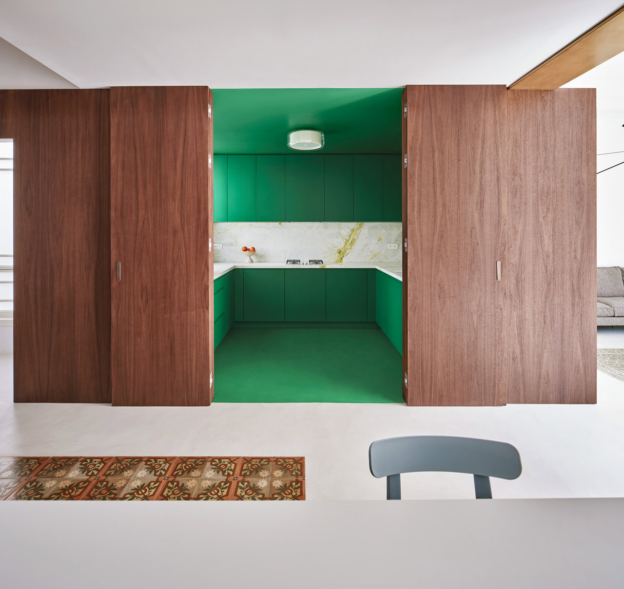Cocina verde escondida por puertas de madera 