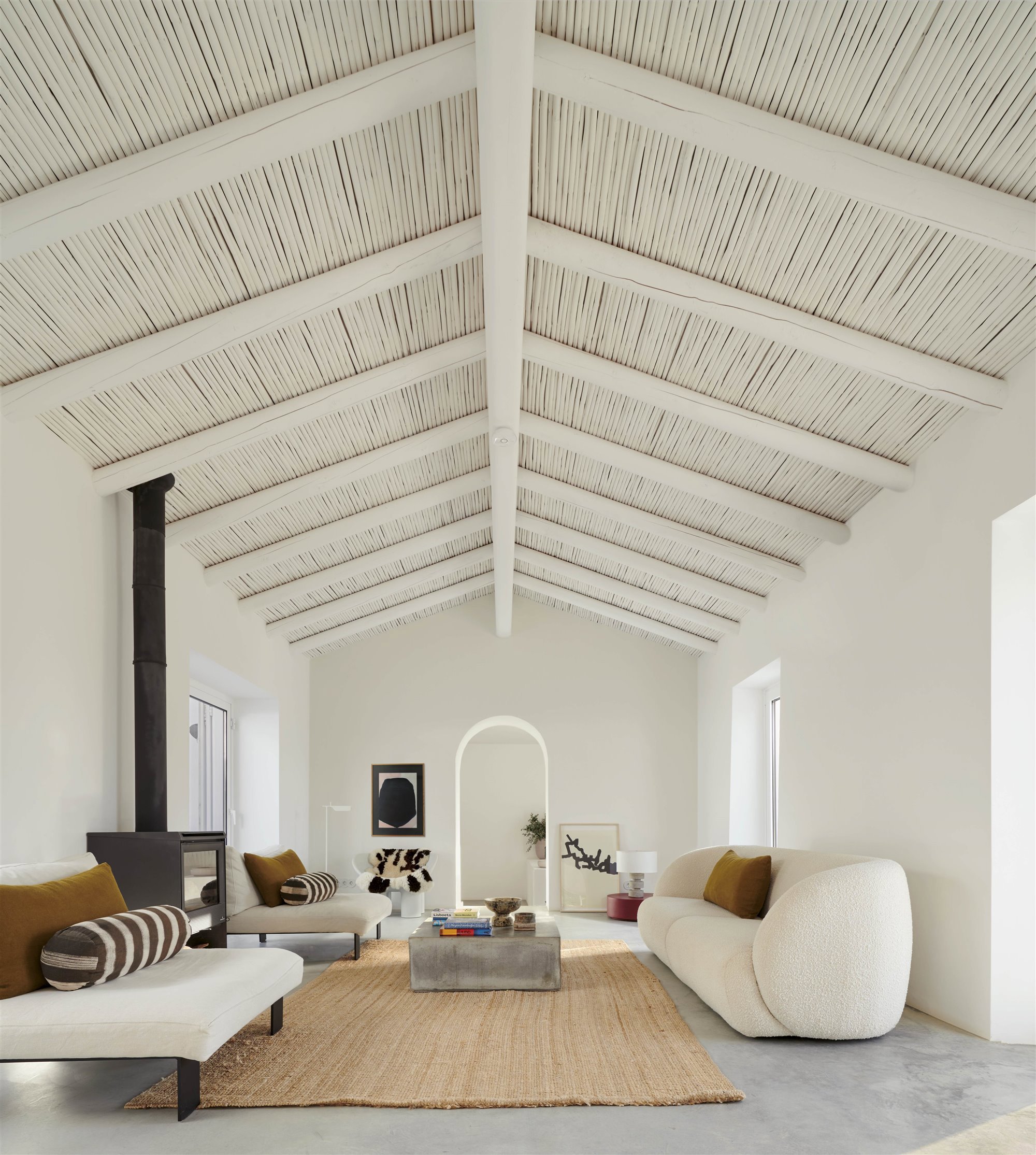 salón blanco con alfombra de rafia y chimenea