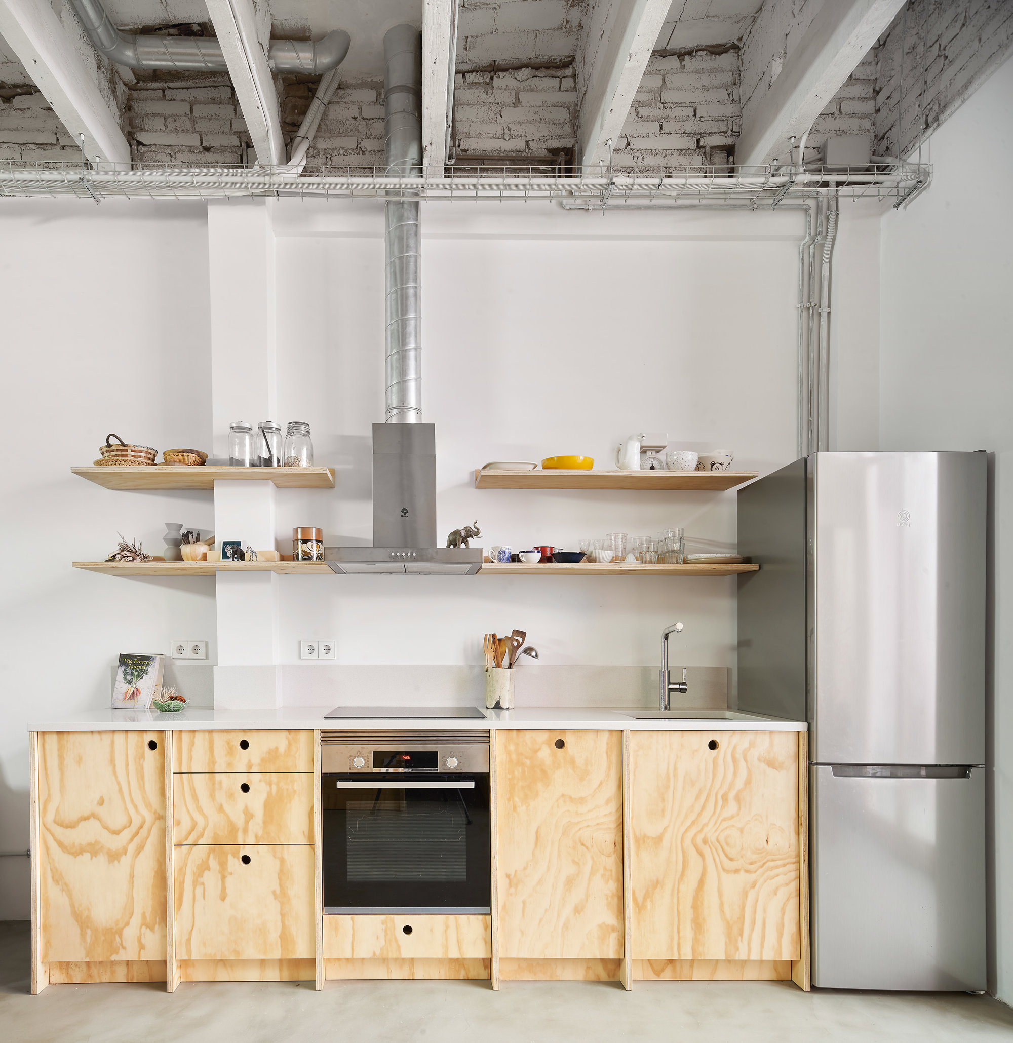 Una cocina con una escalera y una mesa con una planta encima.