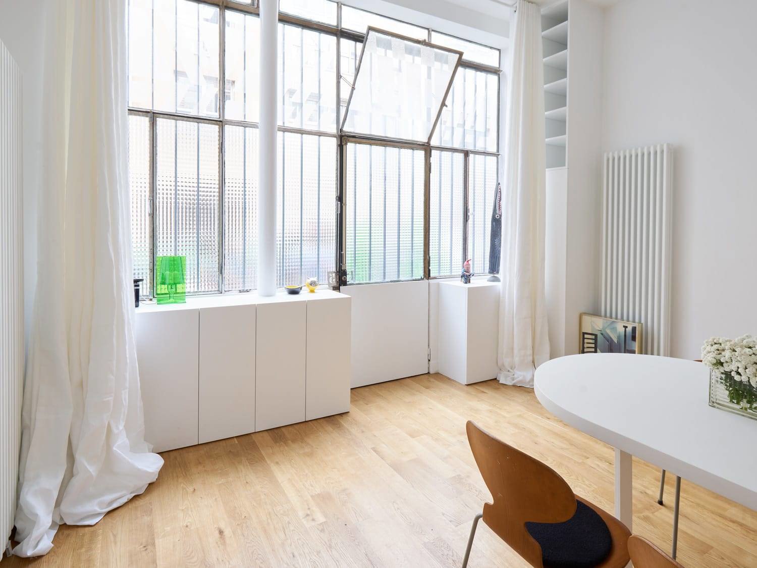 Salon con paredes de cristal ventana practiclable mesa blanca