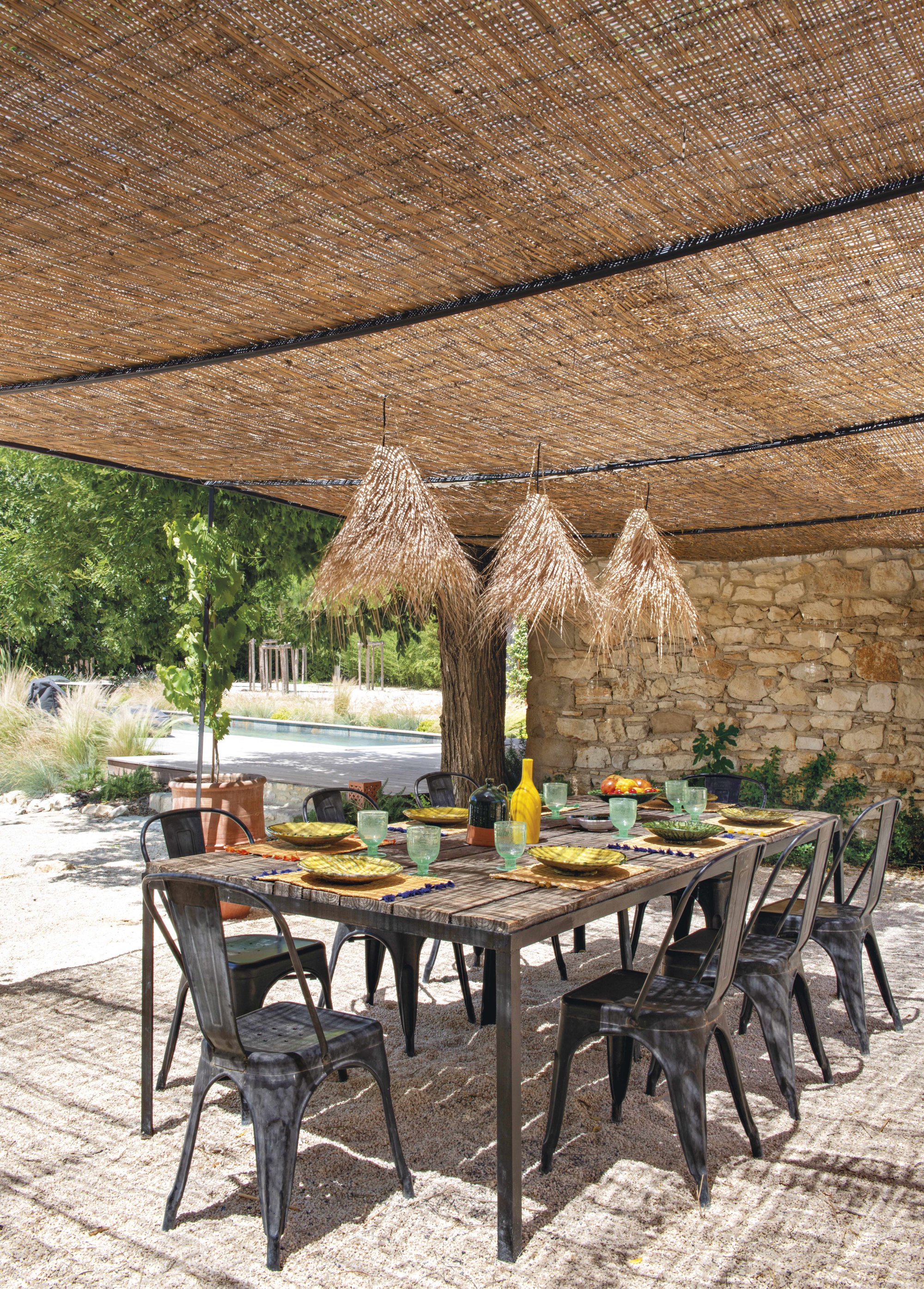 A la sombra de una pérgola de hierro forjada con techo de cañas