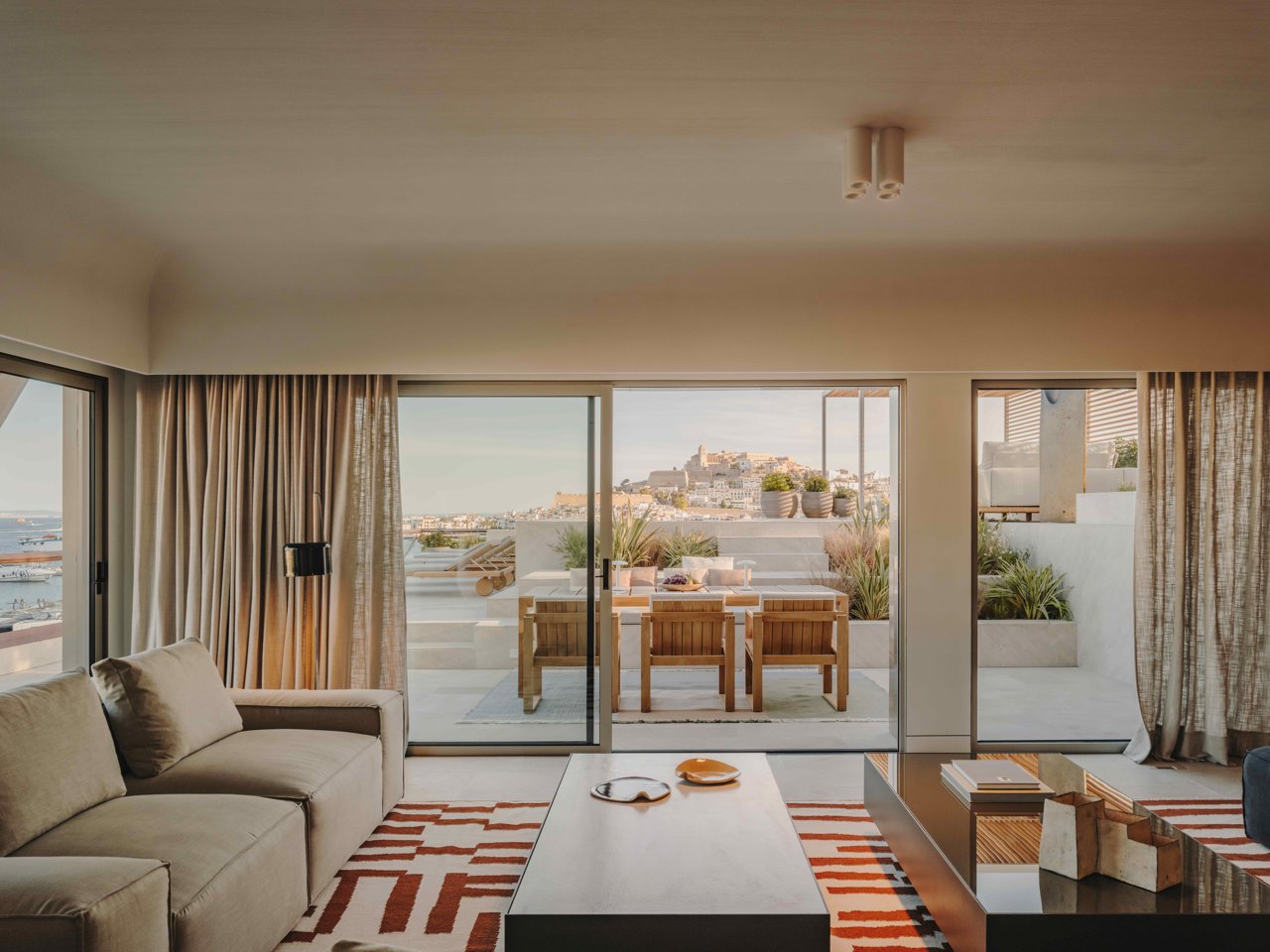 Se han creado piezas de mobiliario a medida que encajan con la amplitud de la habitación, combinadas con lámparas de diseño de Parachilna, Oluce y Martinelli Luce. 