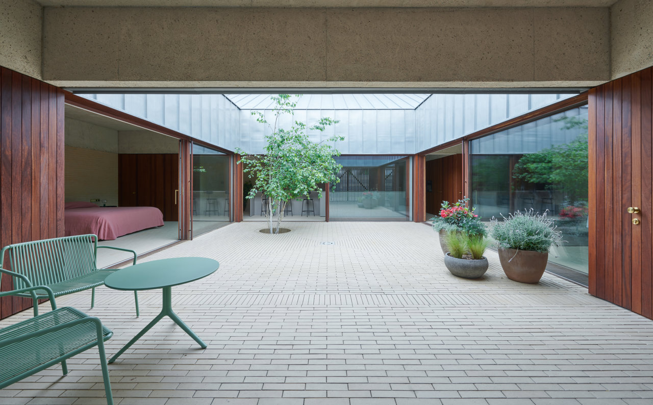 Patio pavimentado con ladrillo de La Paloma. Asientos de la colección Tribeca, diseño de CPM Design para Pedrali que se inspiran en los muebles de exterior de los 60. Mesita Elliot de Patrick Jouin.