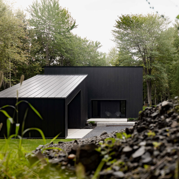 Una cabaña minimalista y deluxe en color negro que se integra en el paisaje