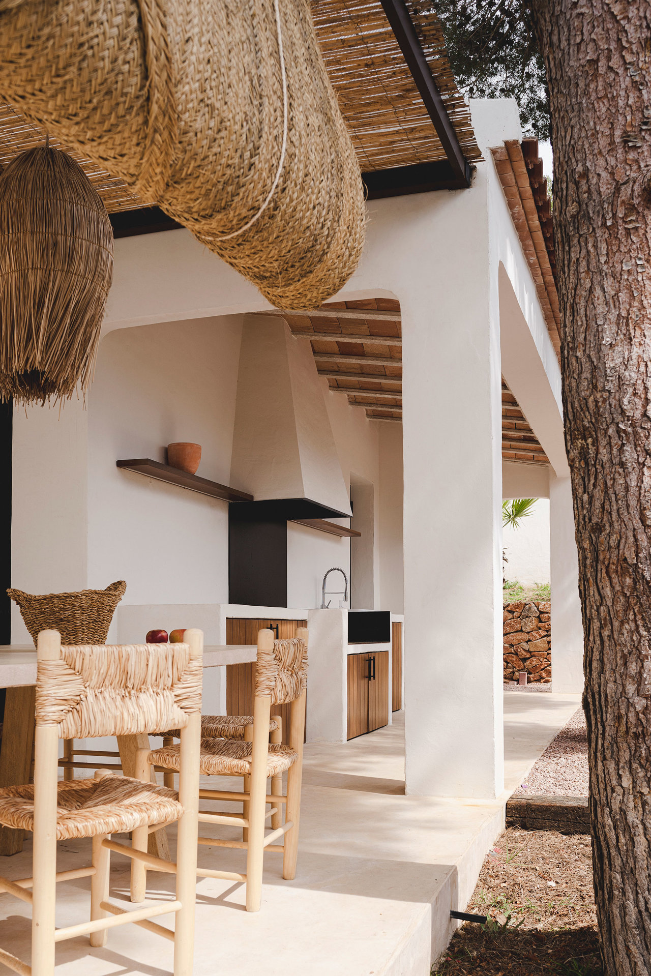 La cocina exterior cuenta con un comedor que mantiene el mismo estilo rústico renovado.