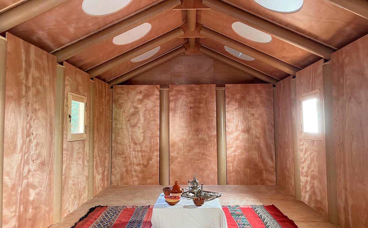 El interior de la Paper Log House, creada con paneles de madera y tubos de papel, ofrece una atmósfera acogedora. 